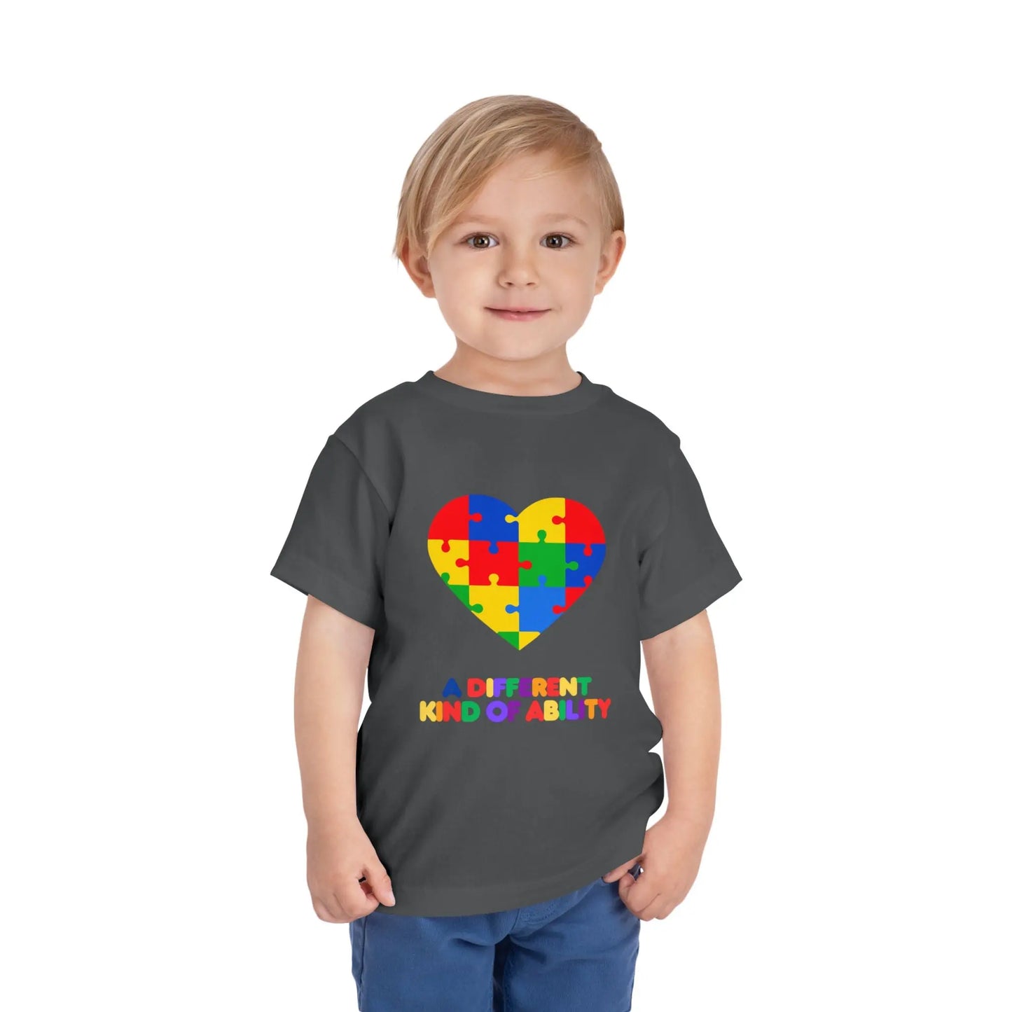 Toddler wearing an Autism Awareness t shirt honoring neurodiversity with this "A Different Kind of Ability" autism awareness toddler tee. Featuring a puzzle heart design, it's a meaningful shirt for little ones. Asphalt