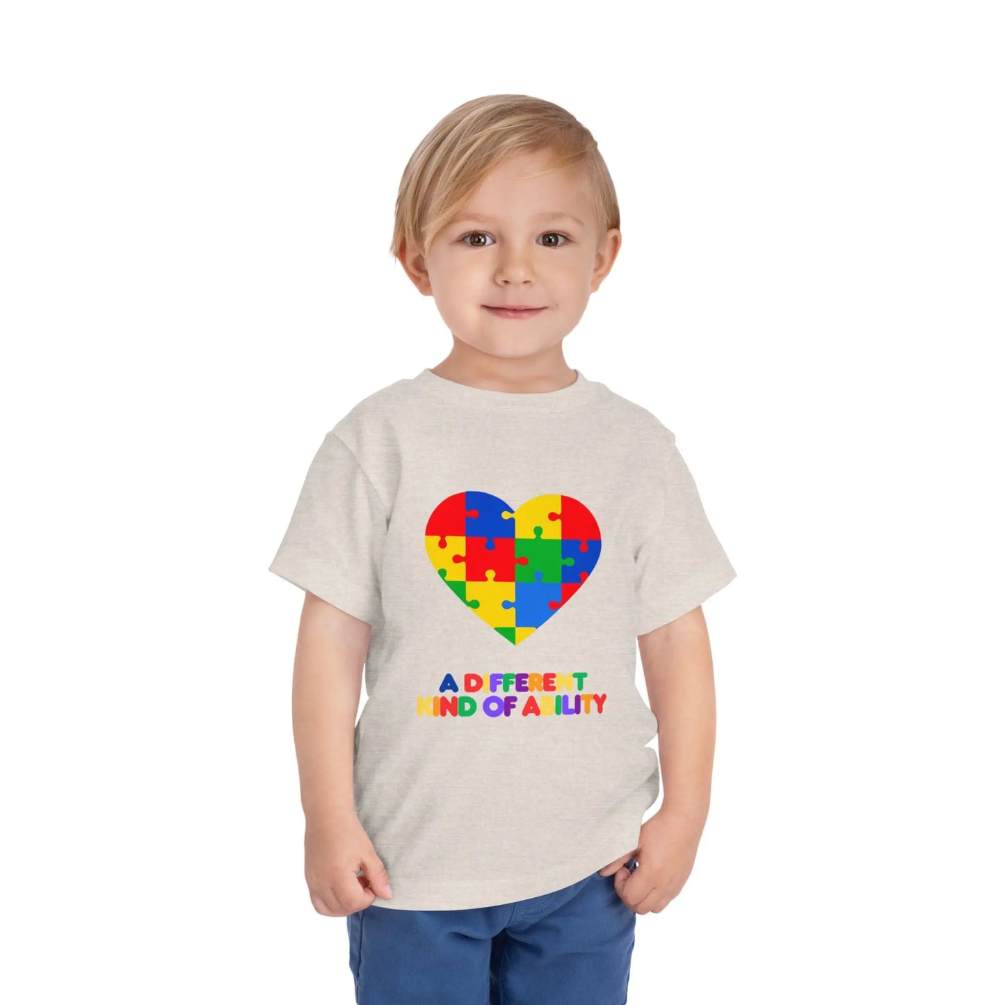 Toddler wearing an Autism Awareness t shirt honoring neurodiversity with this "A Different Kind of Ability" autism awareness toddler tee. Featuring a puzzle heart design, it's a meaningful shirt for little ones. Heather Dust