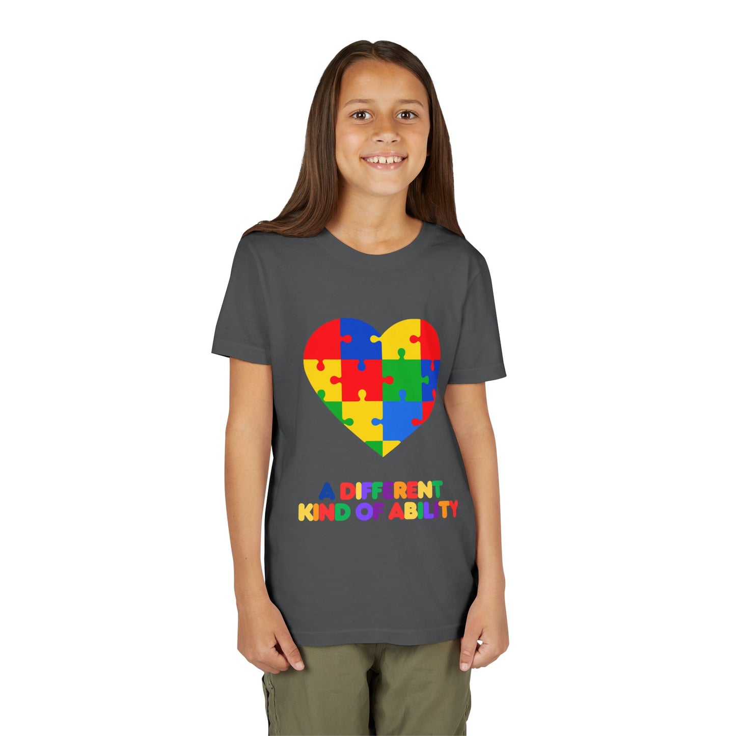 Young girl wearing an Autism Awareness Shirt. Celebrate every unique mind with this "A Different Kind of Ability" autism awareness youth tee. A puzzle heart design that spreads acceptance, love, and neurodiversity, Asphalt