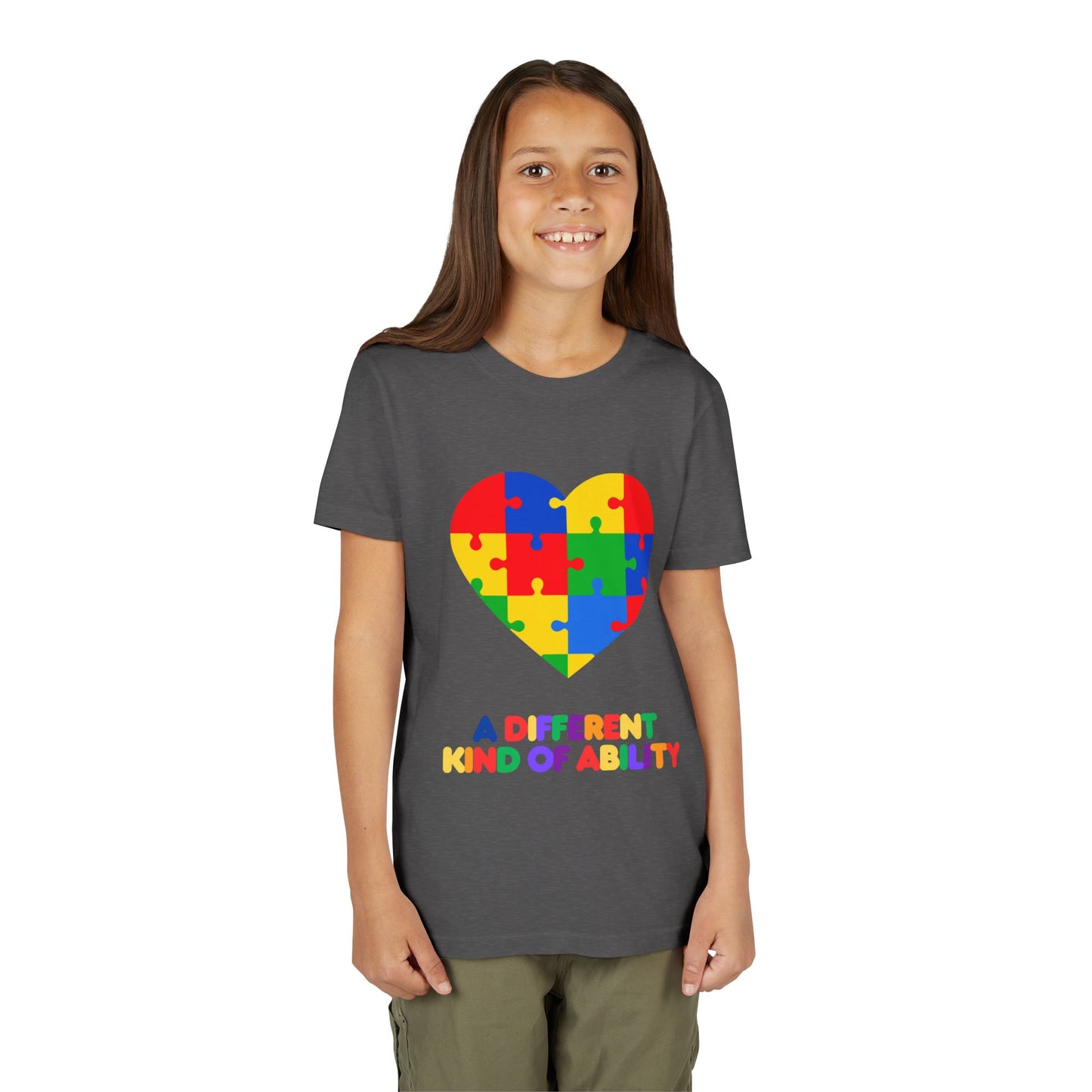 Young girl wearing an Autism Awareness Shirt. Celebrate every unique mind with this "A Different Kind of Ability" autism awareness youth tee. A puzzle heart design that spreads acceptance, love, and neurodiversity, Dark Heather Grey