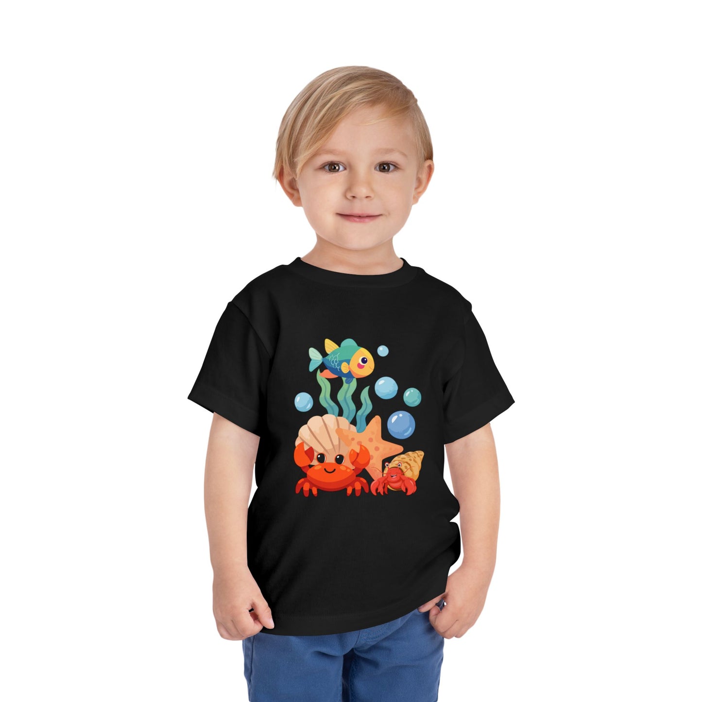 Child wearing a black t-shirt with a colorful underwater-themed graphic on a white background. Playful toddler tee with a crab, fish & shell design. Soft, breathable cotton with tear-away label. Sizes 2T–5T. Perfect for beach days & summer play! Black