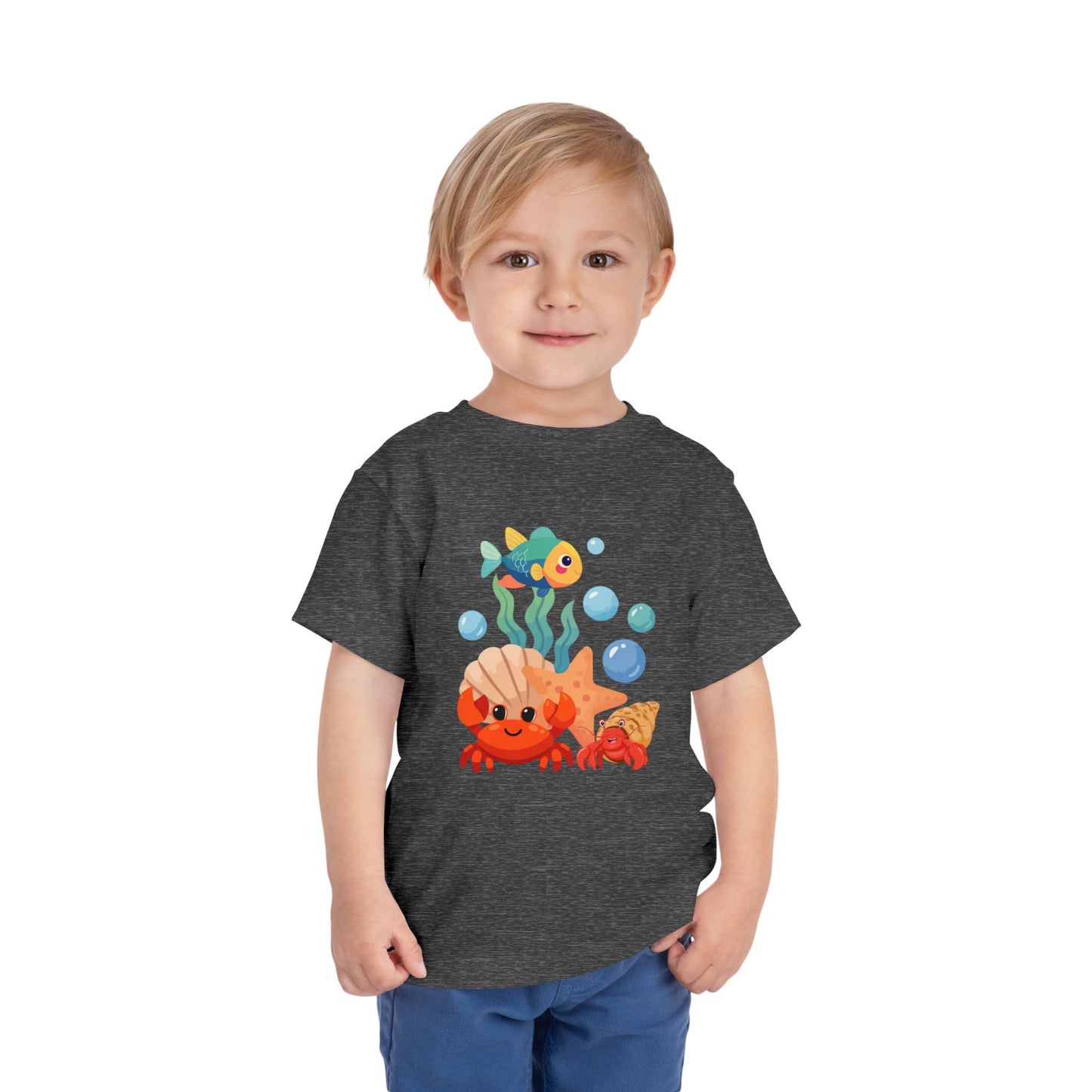Child wearing a Deep Heather Grey t-shirt with a colorful underwater-themed graphic. Playful toddler tee with a crab, fish & shell design. Soft, breathable cotton with tear-away label. Sizes 2T–5T. Perfect for beach days & summer play!
