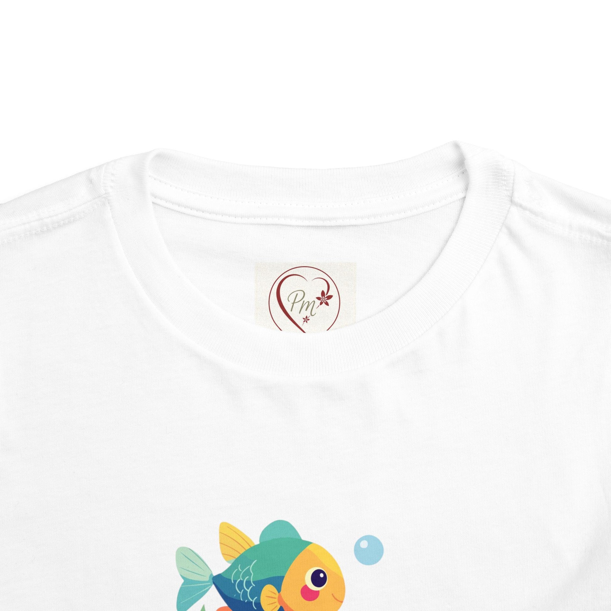  Perfect for beach days & summer play! White t-shirt with a colorful fish design and a PM Creations 25 logo on the chest. 