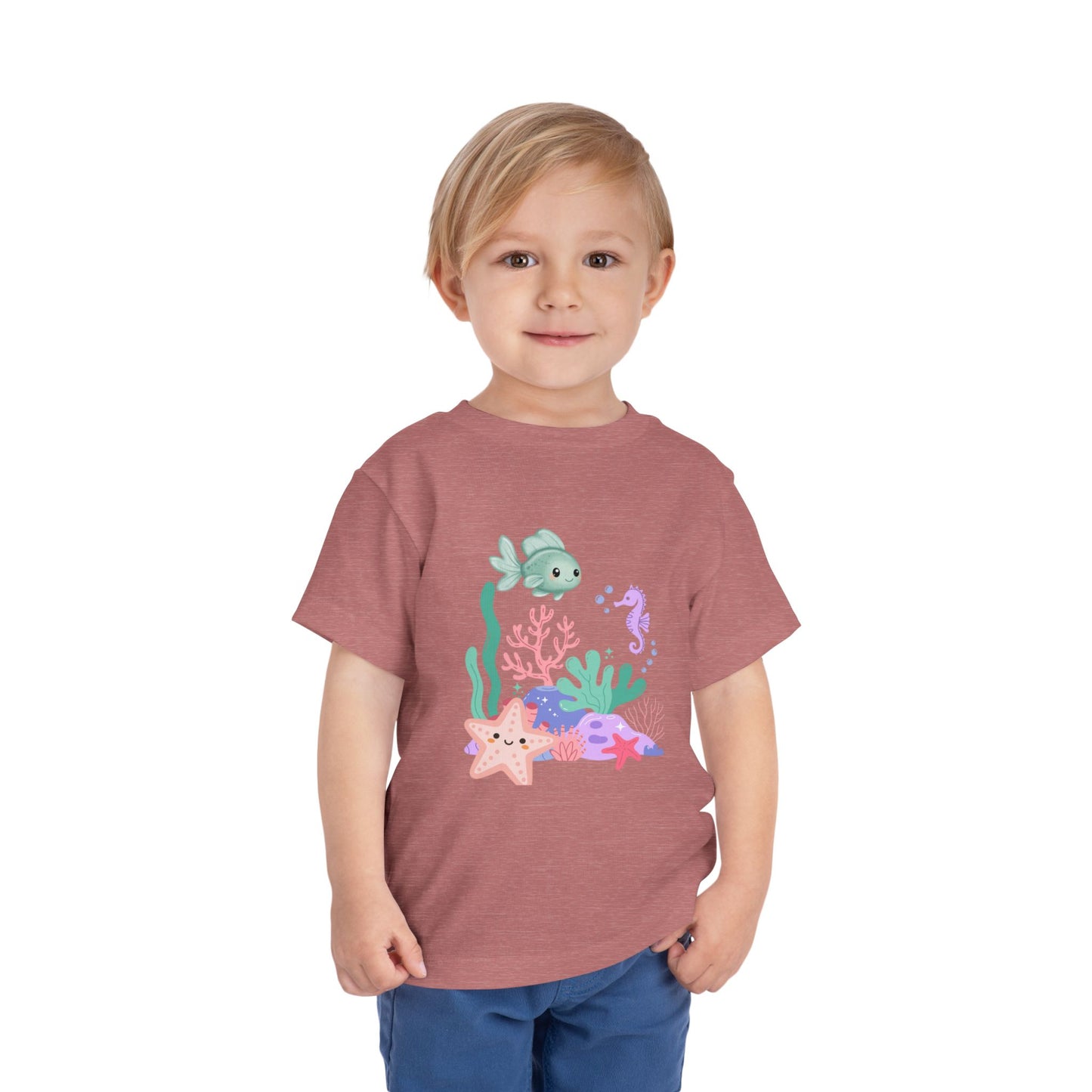 Child wearing a soft, breathable toddler tee featuring pastel sea creatures — fish, seahorse & starfish. Tear-away label, lightweight fabric. Sizes 2T–5T. Shop now! Heather Mauve