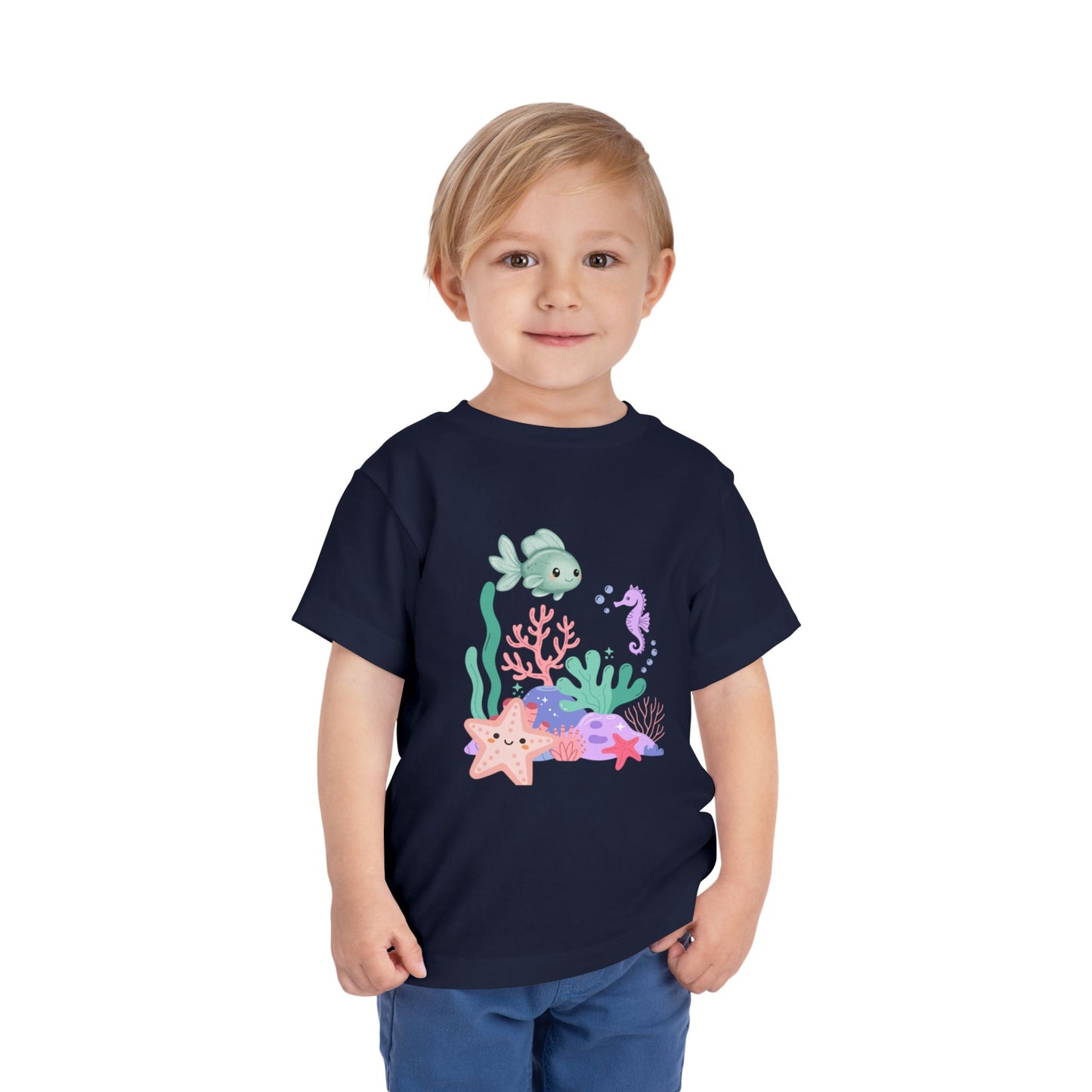 Child wearing a soft, breathable toddler tee featuring pastel sea creatures — fish, seahorse & starfish. Tear-away label, lightweight fabric. Sizes 2T–5T. Shop now! Navy