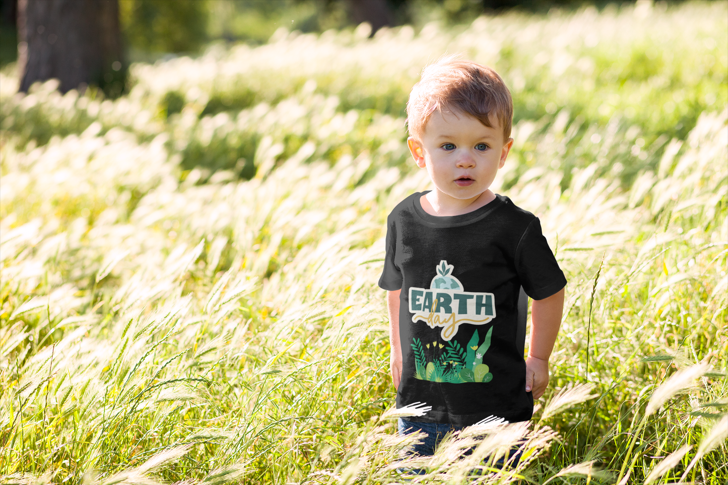 Toddler wearing Earth Day tee with green leafy plant design black
