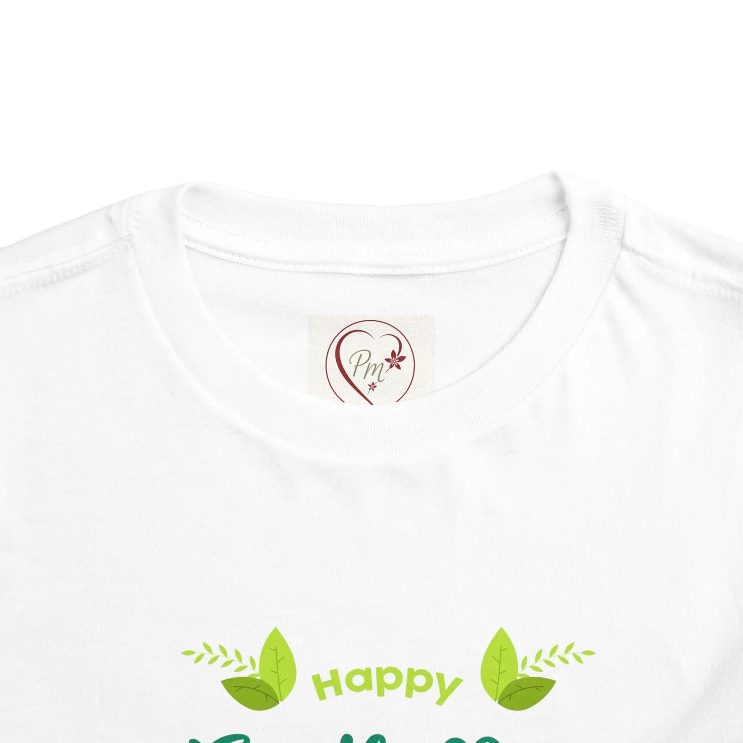 White t-shirt with green leaf design and text on a white background featuring a PM Creations 25 Logo