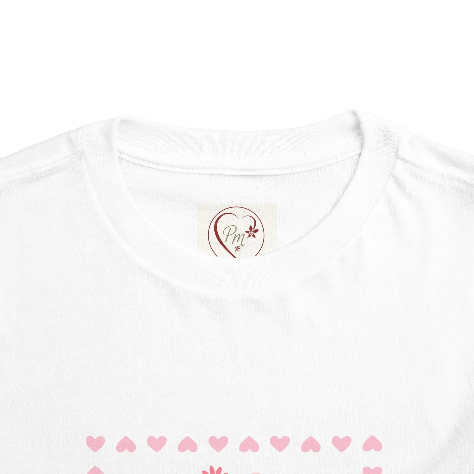 White t-shirt with a heart-shaped PM Creations 25 logo and pink heart patterns on a white background