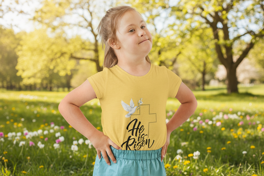 Child wearing a gentle faith-based toddler tee with cross, dove & "He Is Risen" message. Soft cotton perfect for Easter services, baptisms & family gatherings. Heather Yellow Gold