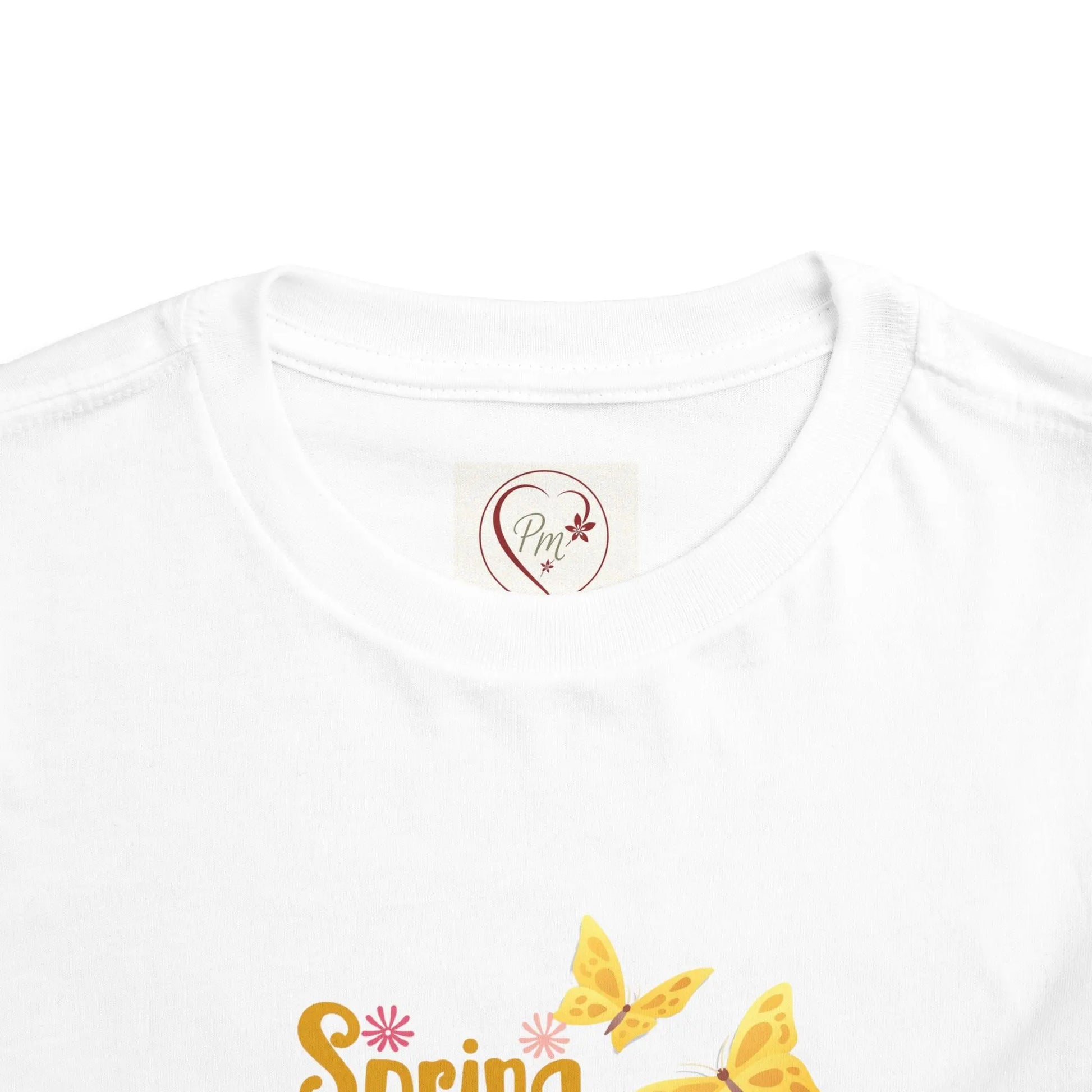White t-shirt with 'Spring' text and butterfly design with the PM Creations 25 logo on the neck tag