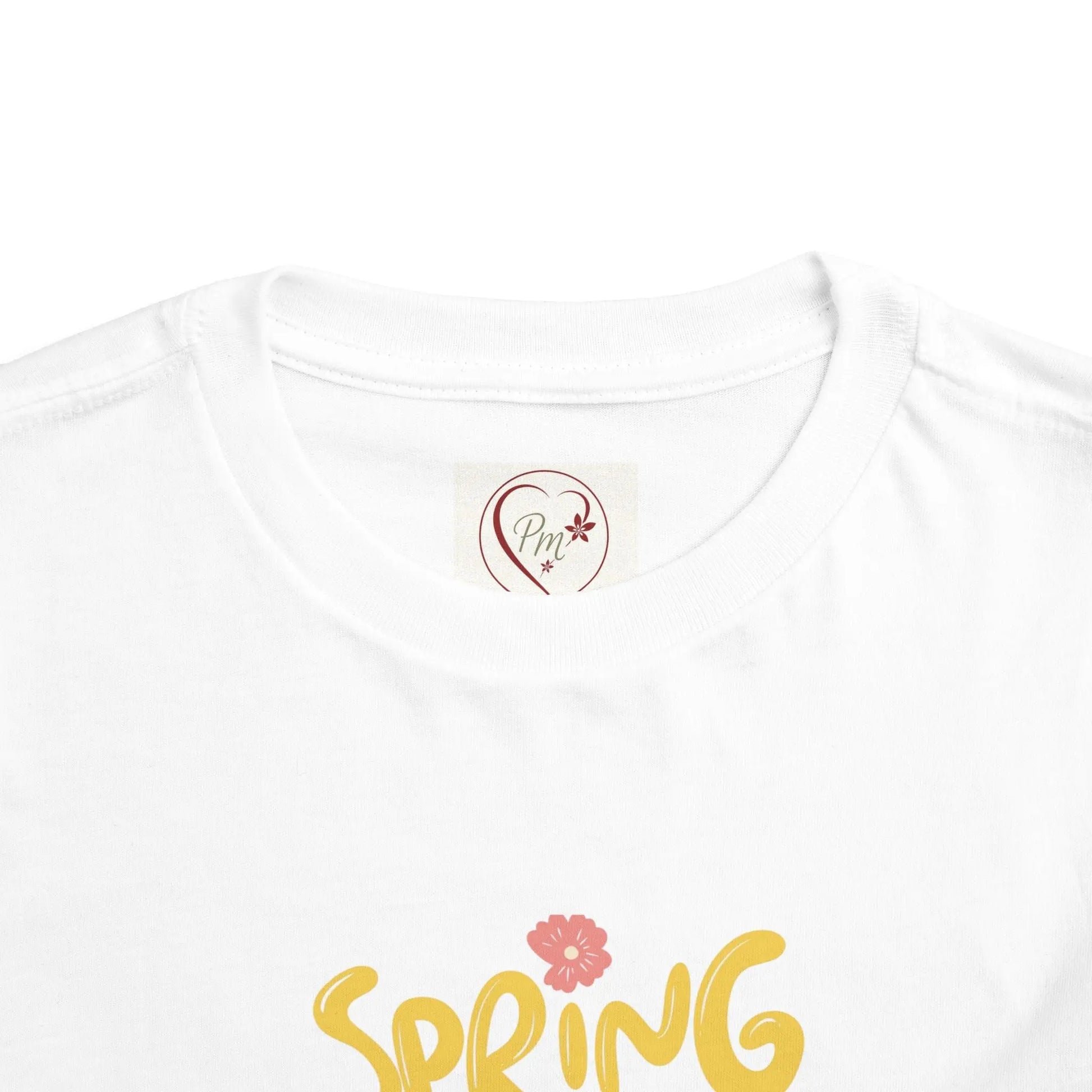 White t-shirt with 'Spring' text and floral design on a white background with PM Creations  25 Logo on neck tag