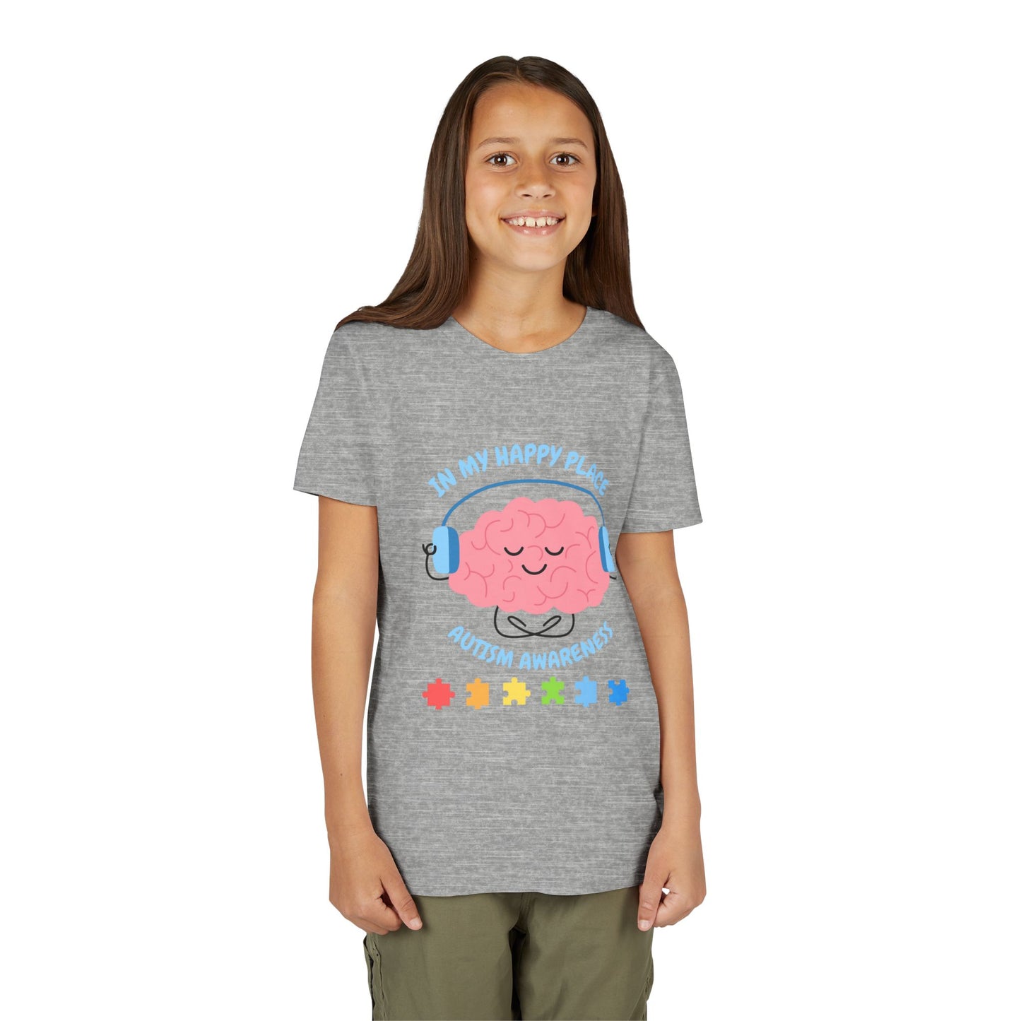 Girl wearing a youth tee for Autism Awareness with smiling brain with headphones and colorful puzzle pieces, "In My Happy Place" graphic. Athletic Heather