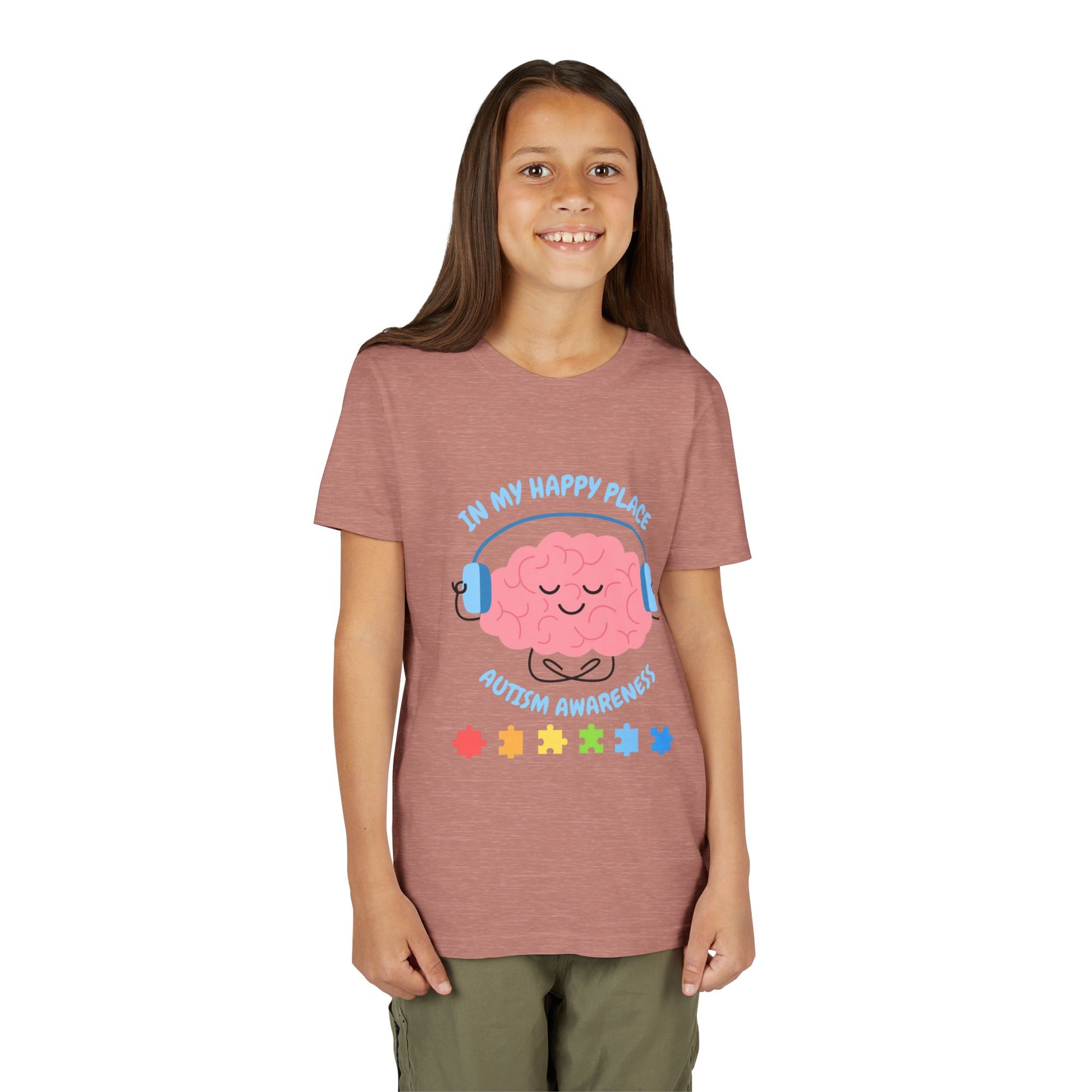 Girl wearing a youth tee for Autism Awareness with smiling brain with headphones and colorful puzzle pieces, "In My Happy Place" graphic. Heather Mauve