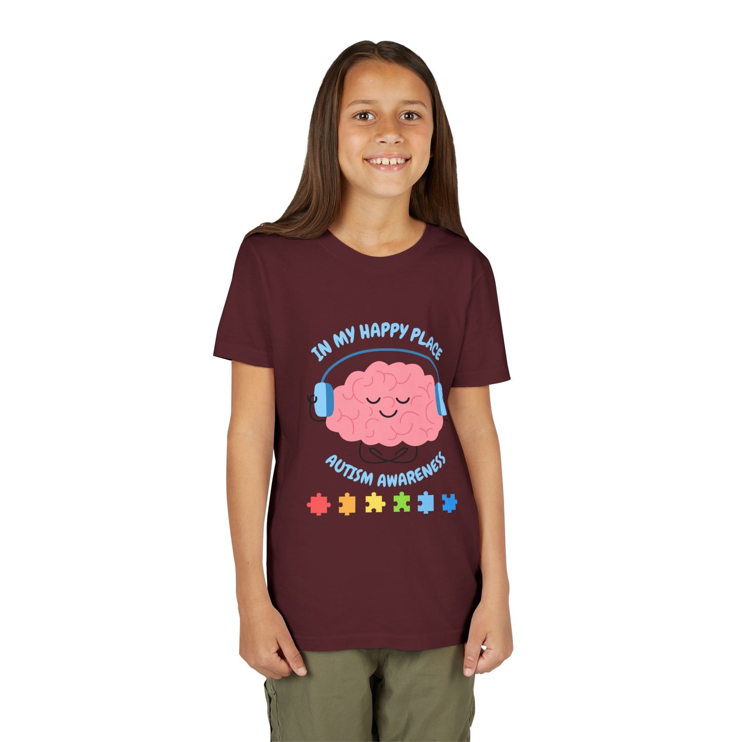 Girl wearing a youth tee for Autism Awareness with smiling brain with headphones and colorful puzzle pieces, "In My Happy Place" graphic. Maroon