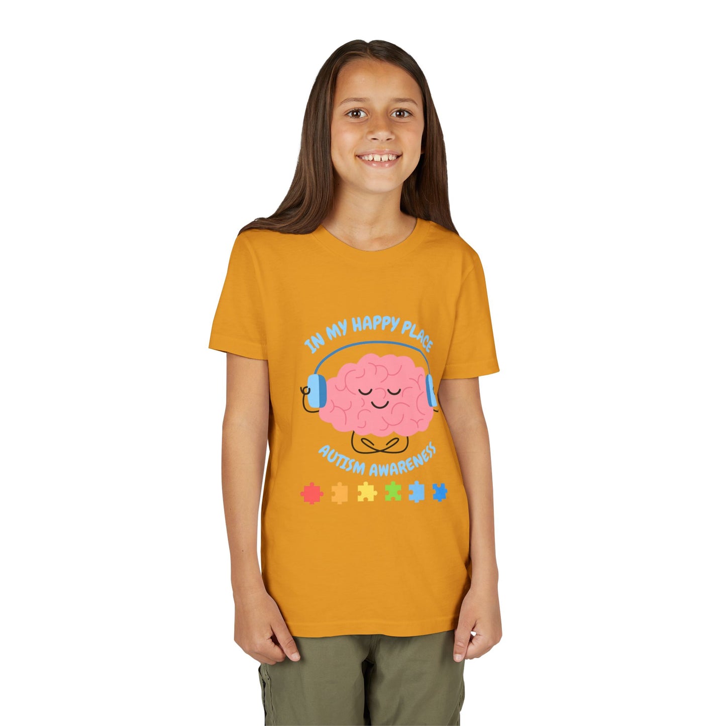Girl wearing a youth tee for Autism Awareness with smiling brain with headphones and colorful puzzle pieces, "In My Happy Place" graphic. Mustard