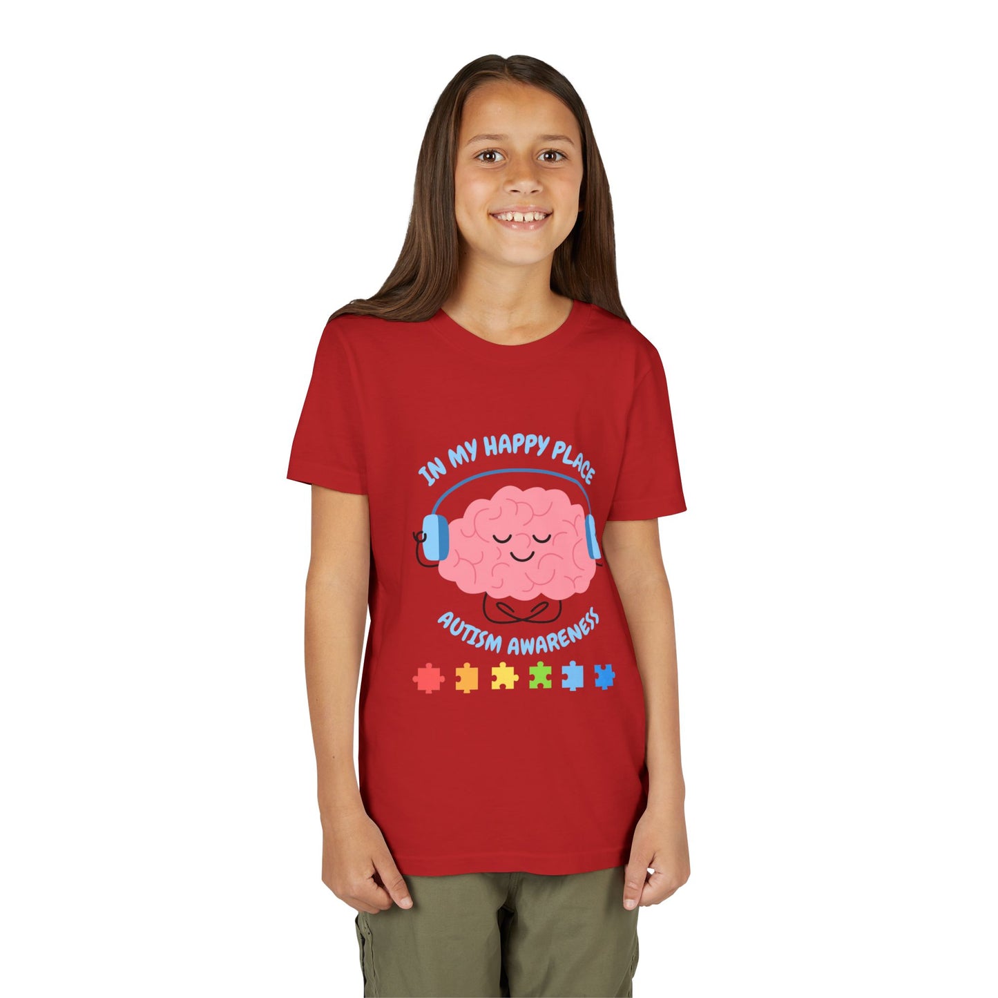 Girl wearing a youth tee for Autism Awareness with smiling brain with headphones and colorful puzzle pieces, "In My Happy Place" graphic. Red