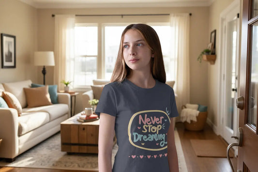 Youth wearing this encouraging youth tee with "Never Stop Dreaming" message. Soft cotton, perfect for school, everyday wear, and inspiring creativity. Motivational kids' clothing. 