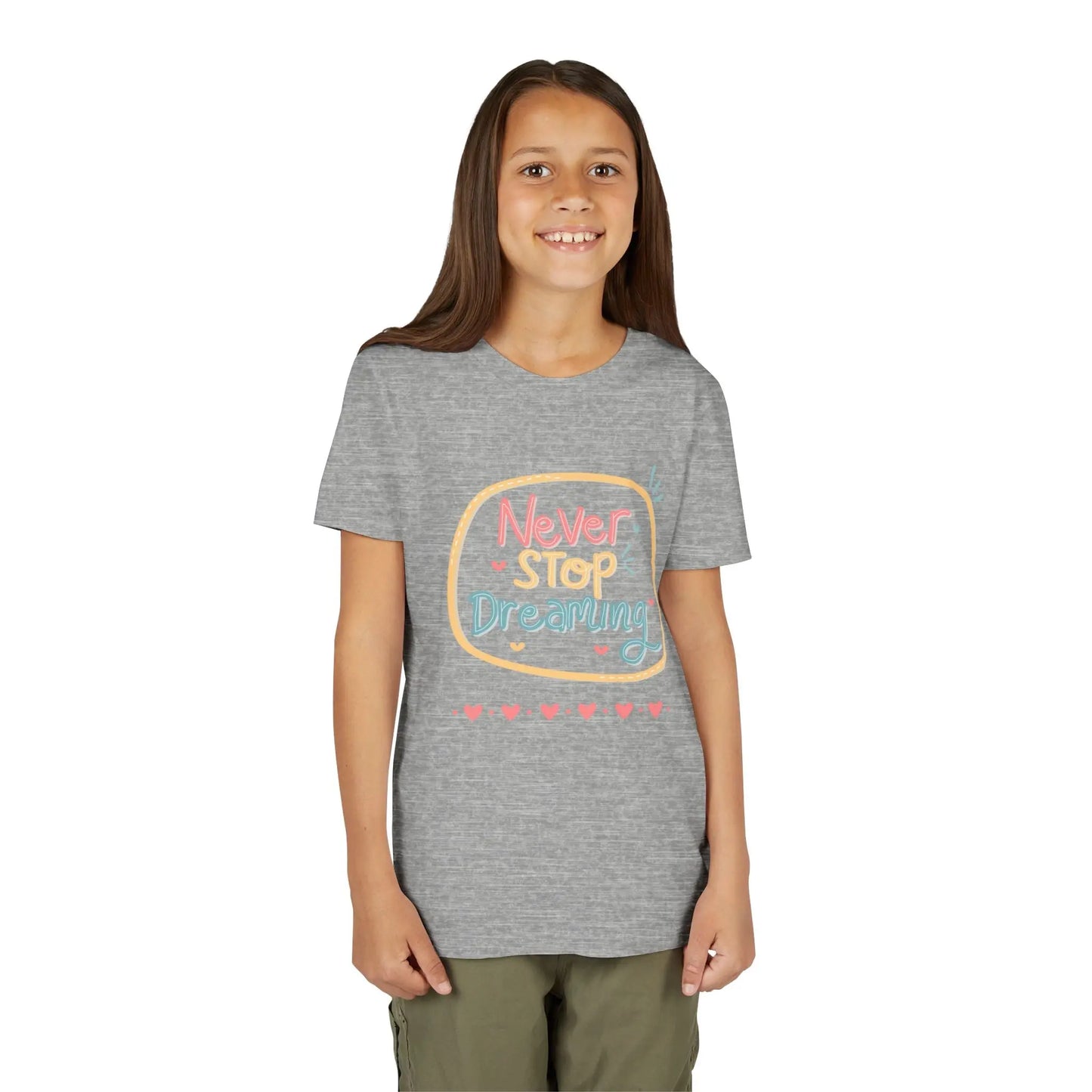 Youth wearing this encouraging youth tee with "Never Stop Dreaming" message. Soft cotton, perfect for school, everyday wear, and inspiring creativity. Motivational kids' clothing. Athletic Heather