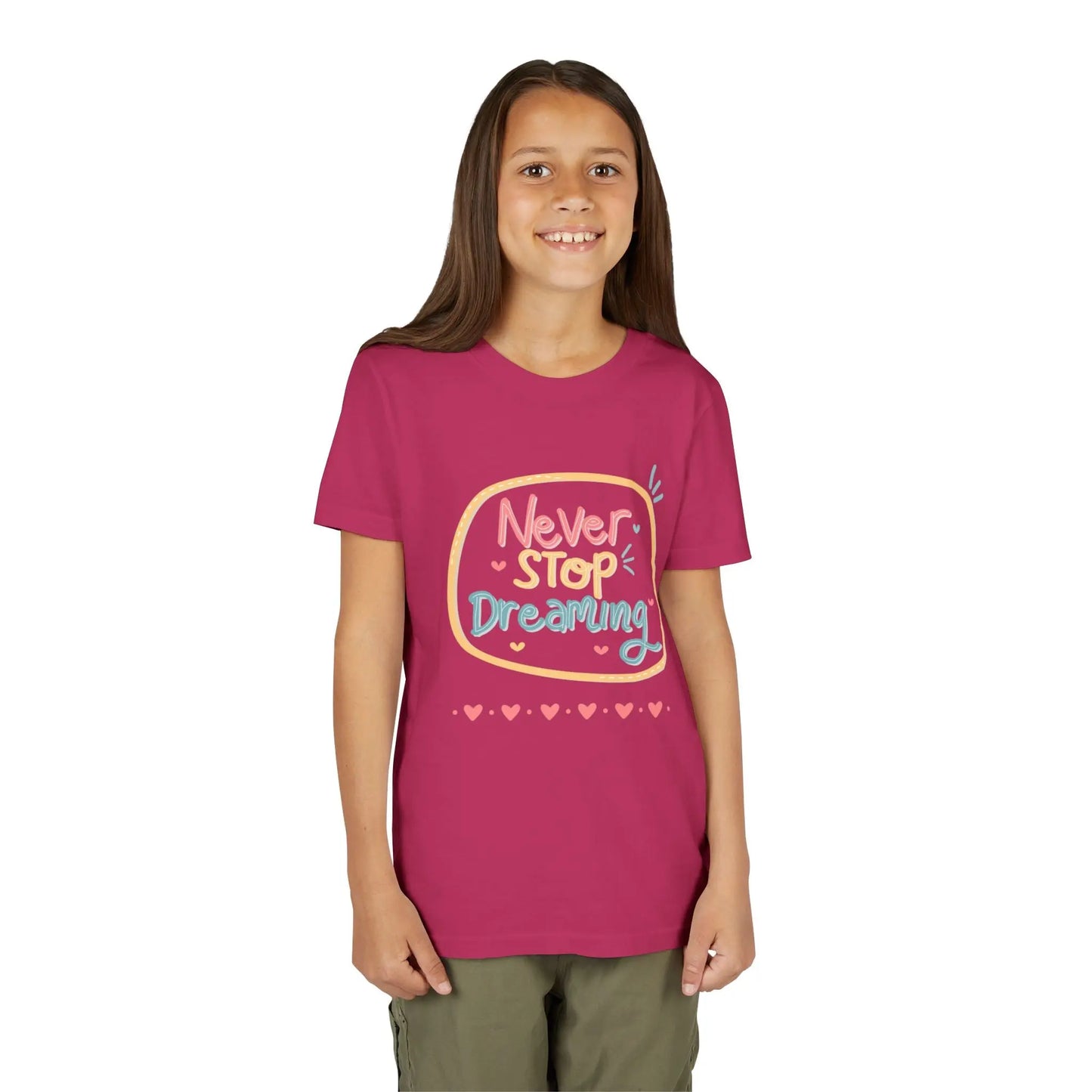Youth wearing this encouraging youth tee with "Never Stop Dreaming" message. Soft cotton, perfect for school, everyday wear, and inspiring creativity. Motivational kids' clothing. Berry