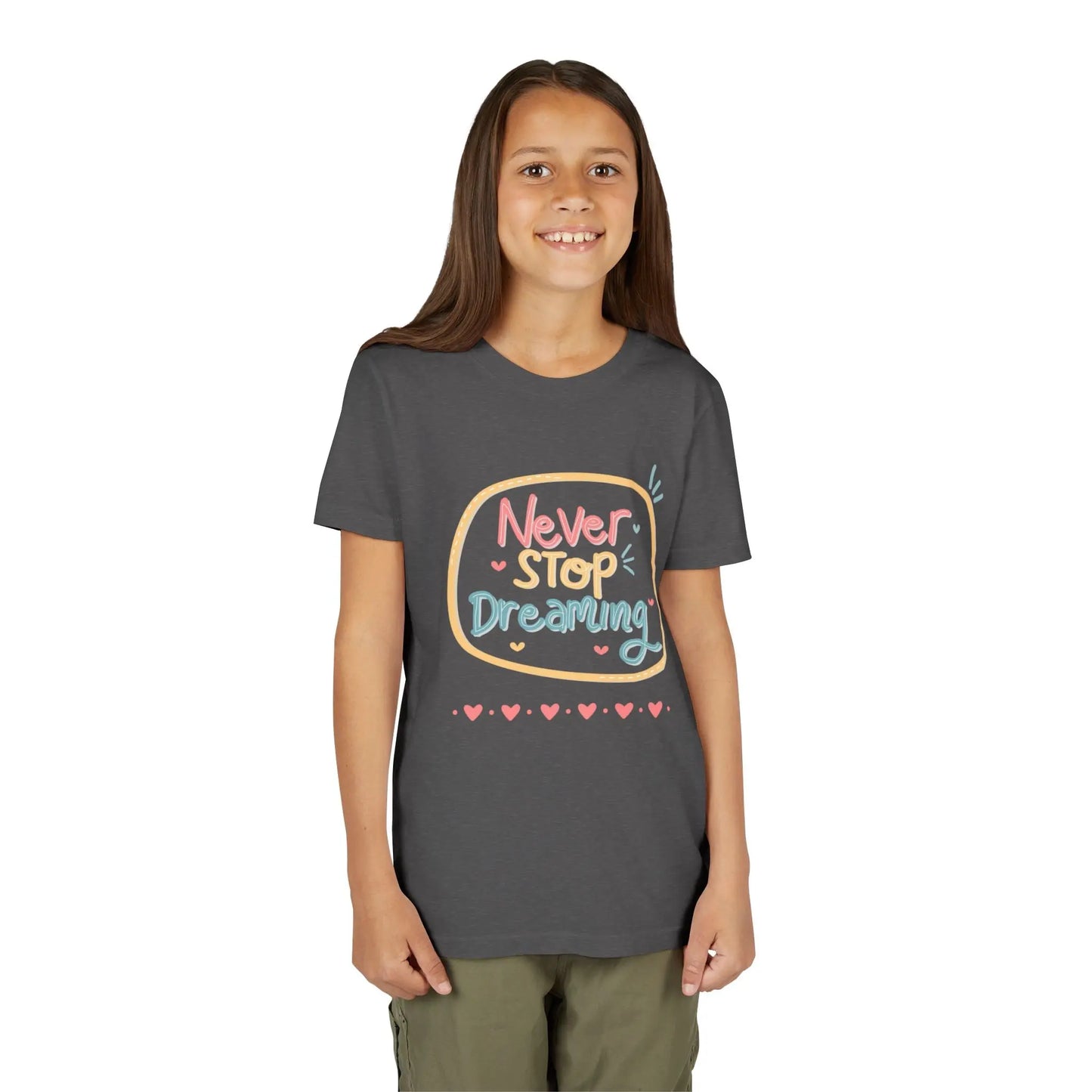 Youth wearing this encouraging youth tee with "Never Stop Dreaming" message. Soft cotton, perfect for school, everyday wear, and inspiring creativity. Motivational kids' clothing. Dark Heather Grey
