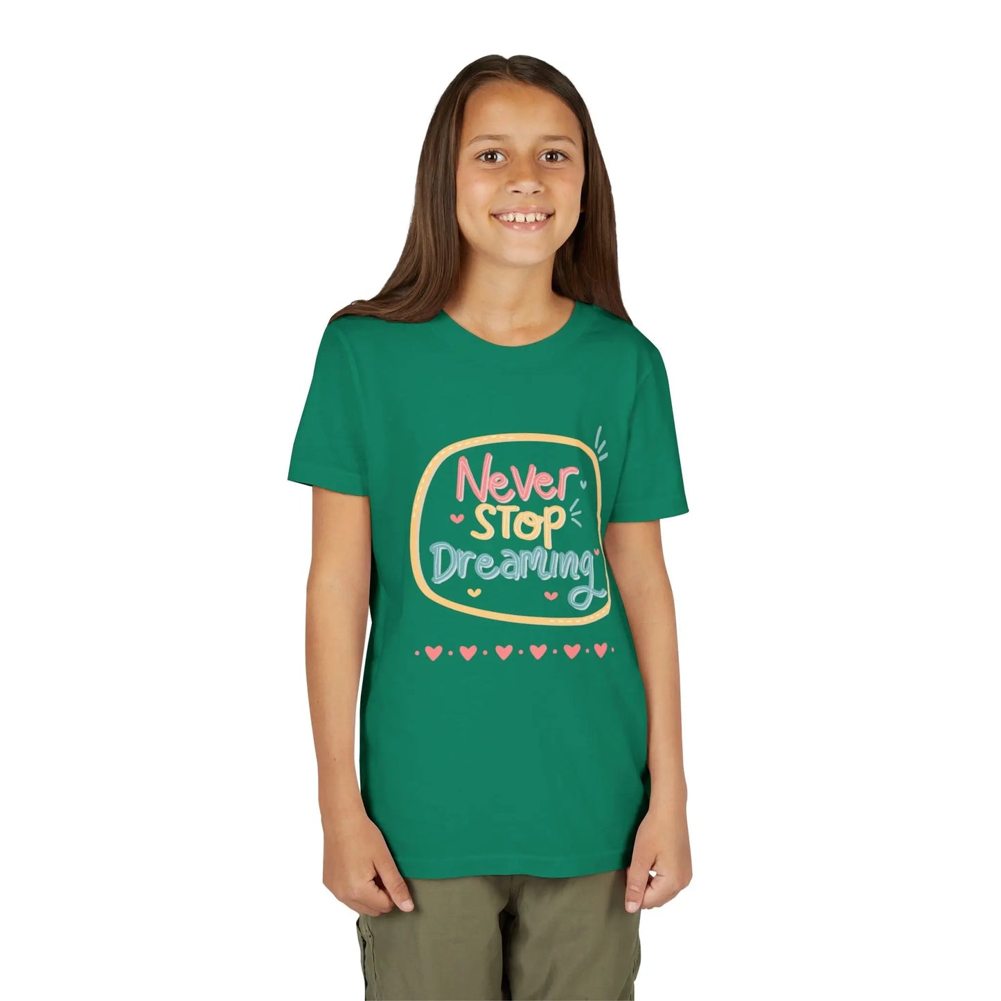 Youth wearing this encouraging youth tee with "Never Stop Dreaming" message. Soft cotton, perfect for school, everyday wear, and inspiring creativity. Motivational kids' clothing. Kelly Green