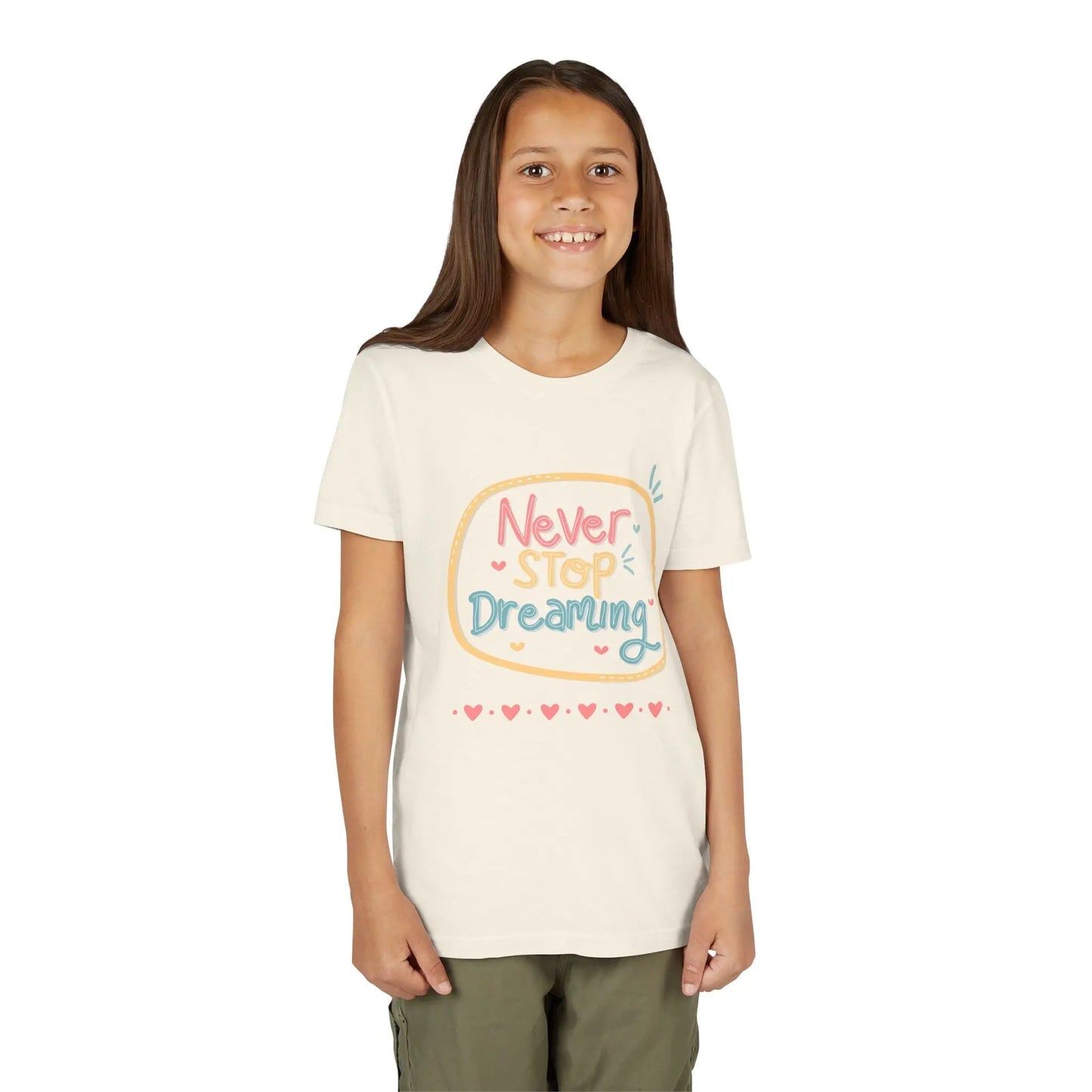 Youth wearing this encouraging youth tee with "Never Stop Dreaming" message. Soft cotton, perfect for school, everyday wear, and inspiring creativity. Motivational kids' clothing. Natural