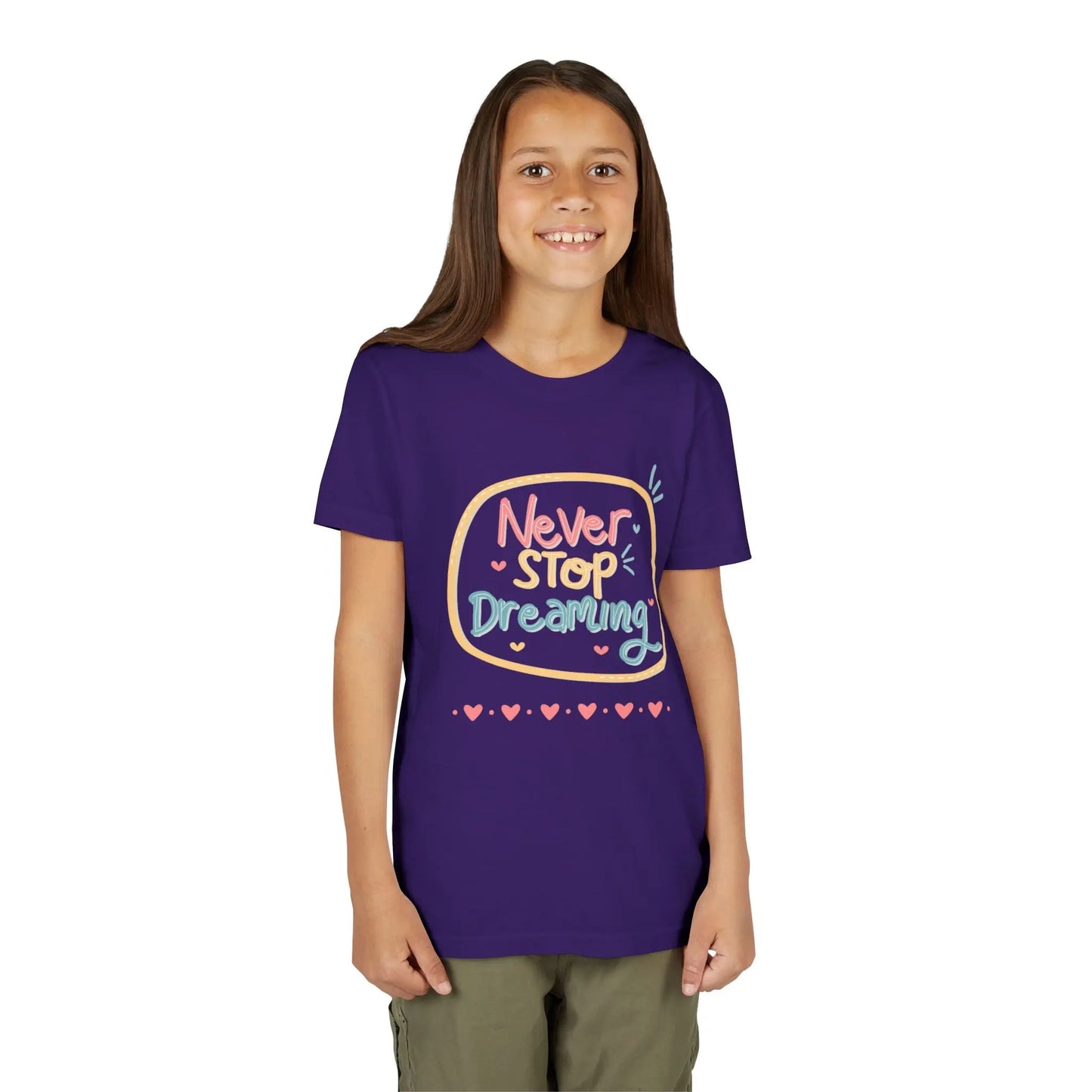 Youth wearing this encouraging youth tee with "Never Stop Dreaming" message. Soft cotton, perfect for school, everyday wear, and inspiring creativity. Motivational kids' clothing. Team Purple