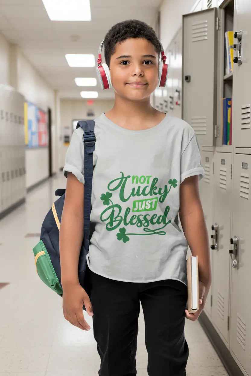 Youth wearing Not Lucky Just Blessed tee with shamrocks and faith-based message, Athletic Grey
