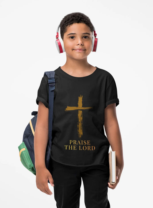 Child wearing a soft, faith-inspired youth tee featuring a painterly brushstroke cross and "Praise The Lord." Perfect for church, Sunday school, Easter, and everyday Christian wear.