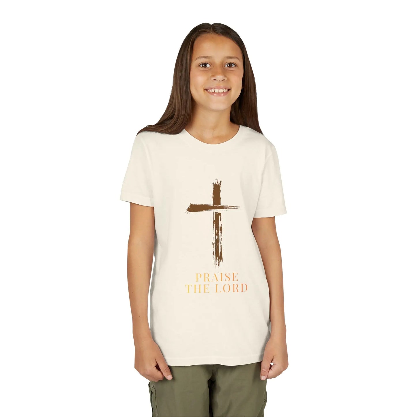 Young girl wearing a soft, faith-inspired youth tee featuring a painterly brushstroke cross and "Praise The Lord." Perfect for church, Sunday school, Easter, and everyday Christian wear. Natural