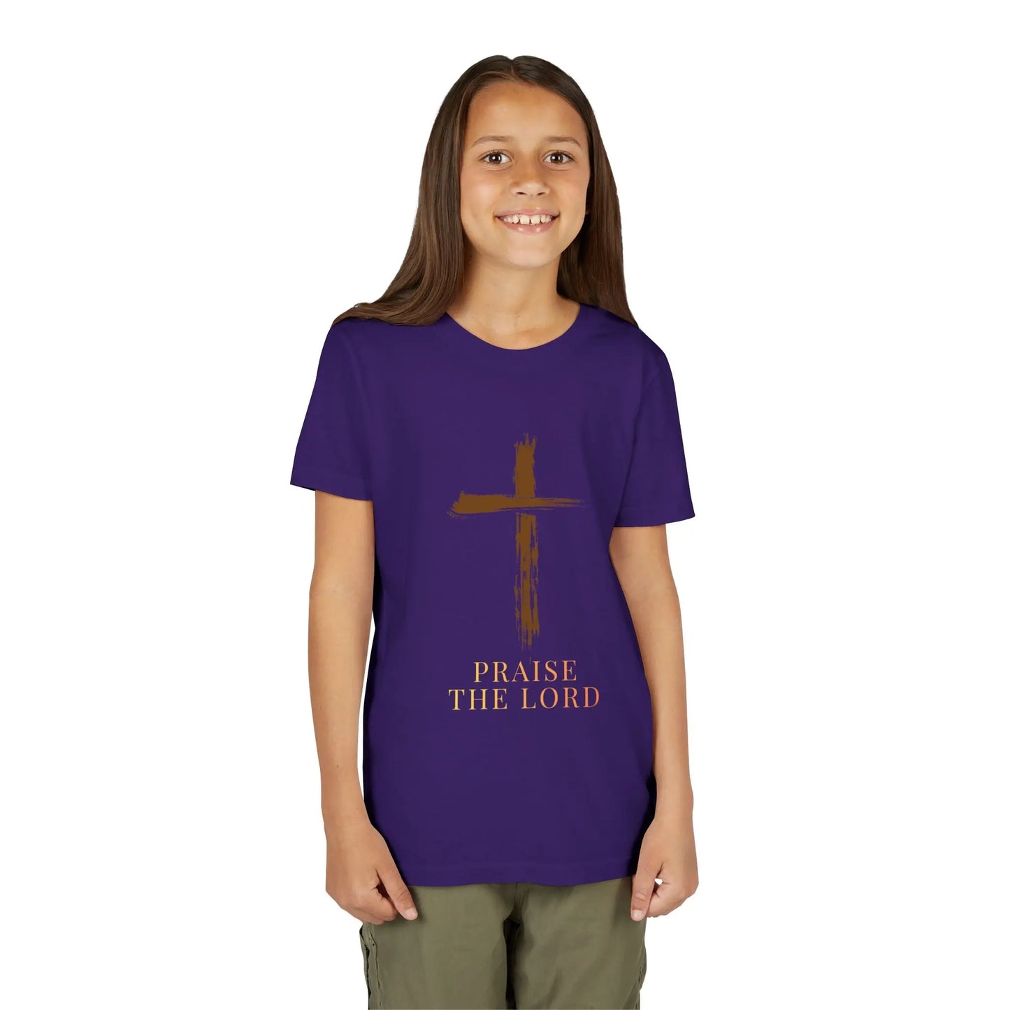 Young girl wearing a Girl wearing a soft, faith-inspired youth tee featuring a painterly brushstroke cross and "Praise The Lord." Perfect for church, Sunday school, Easter, and everyday Christian wear. Team Purple