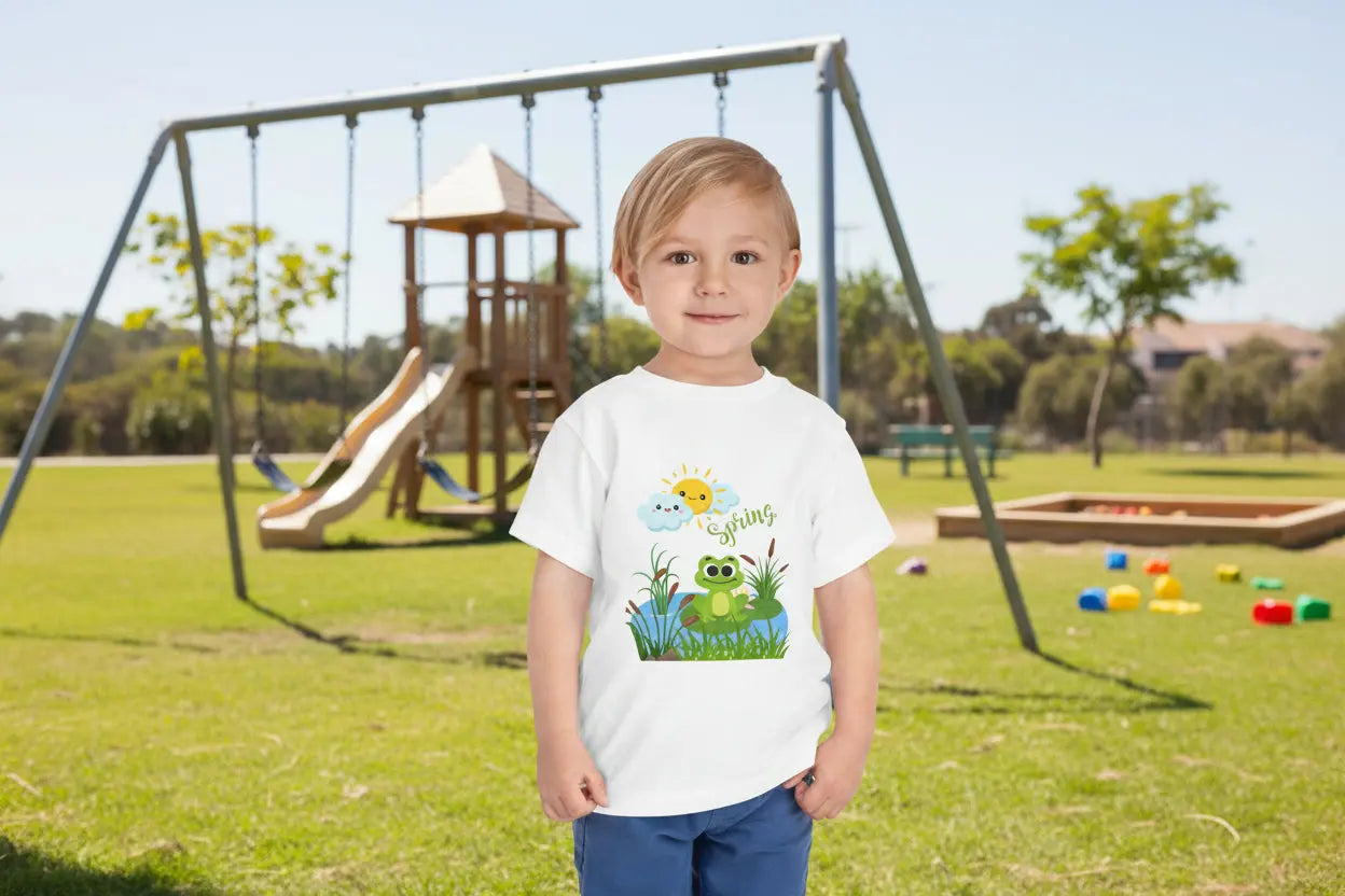 Toddler wearing an adorable toddler tee with spring frog pond graphic. Soft cotton, perfect for Easter, spring outfits, and playful adventures. Cute kids' clothing for toddlers.