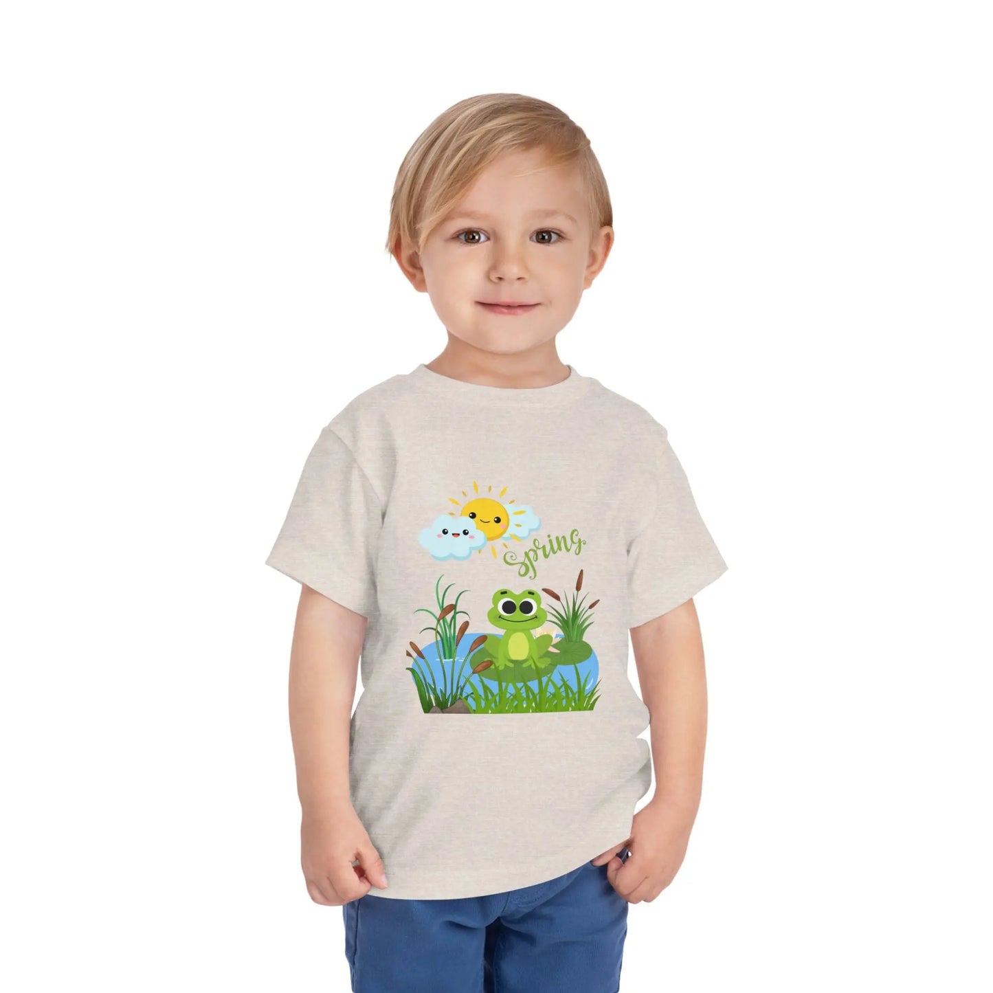 Toddler wearing an adorable toddler tee with spring frog pond graphic. Soft cotton, perfect for Easter, spring outfits, and playful adventures. Cute kids' clothing for toddlers. Heather Dust