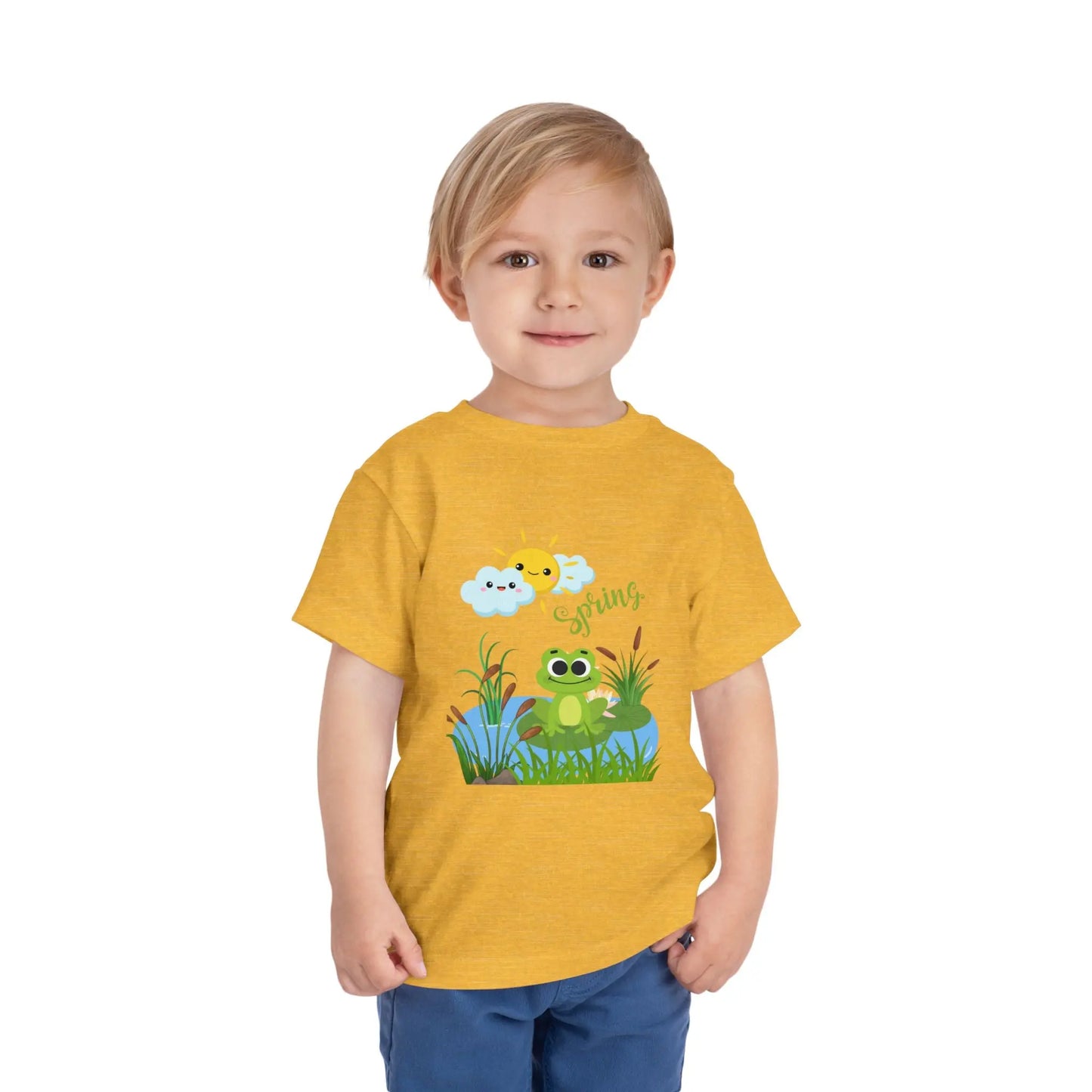Toddler wearing an adorable toddler tee with spring frog pond graphic. Soft cotton, perfect for Easter, spring outfits, and playful adventures. Cute kids' clothing for toddlers. Heather Yellow Gold