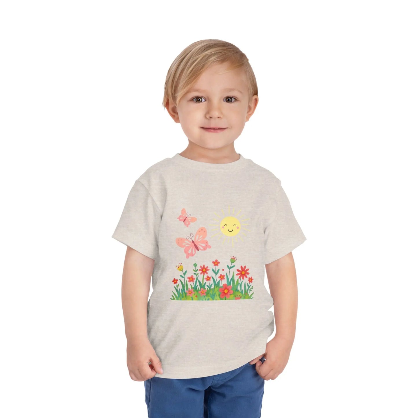 Toddler wearing a cheerful toddler tee with smiling sun, butterflies, and wildflowers. Soft cotton, perfect for spring, playdates, and outdoor adventures. Bright kids' clothing. Heather Dust