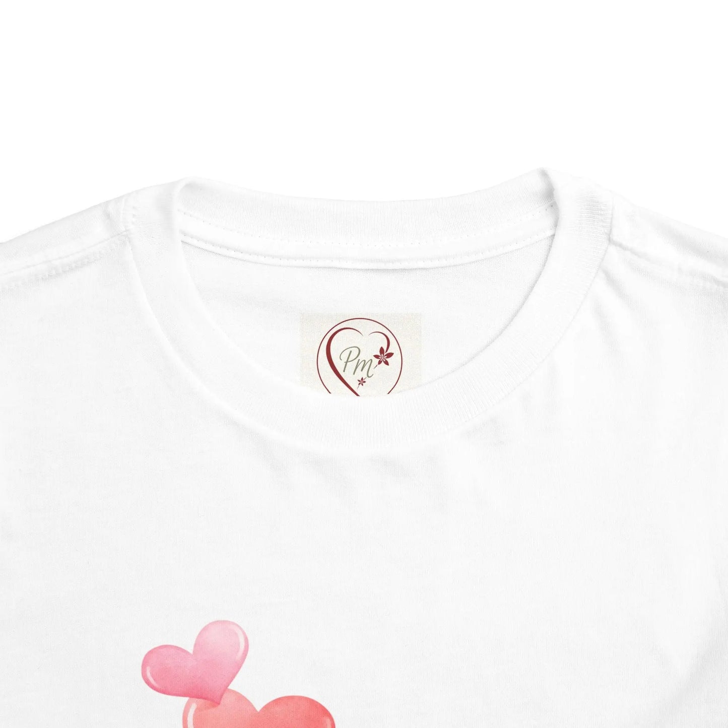 White t-shirt with a PM Creations 25 logo and pink heart design on a white background