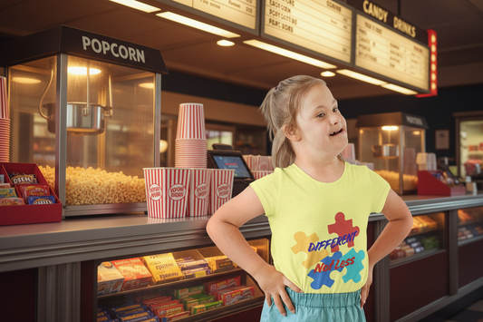 Toddler wearing Different Not Less tee with colorful autism puzzle pieces,
Yellow