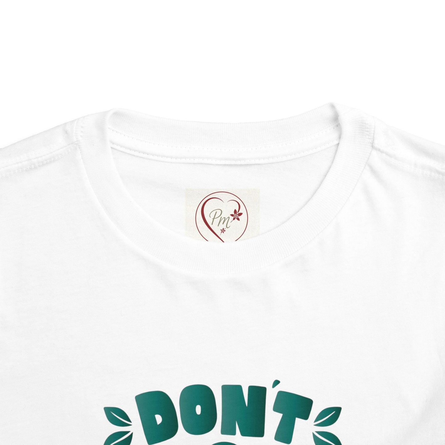 White t-shirt with green text and a PM Creations 25 logo on a white background