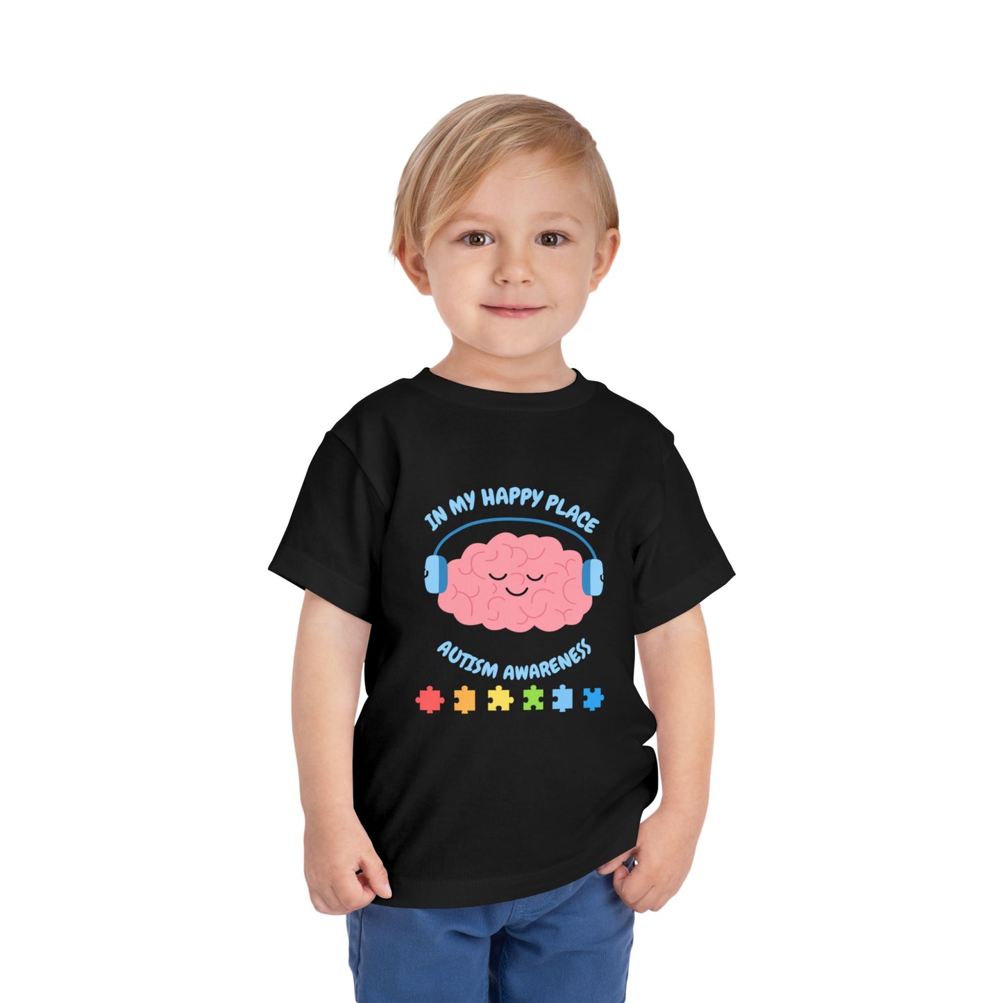 Child wearing a black t-shirt with autism awareness design on a white background. Shop our comfortable Toddler Tee featuring "In My Happy Place" autism awareness design, perfect for preschool and toddler kids. Black
