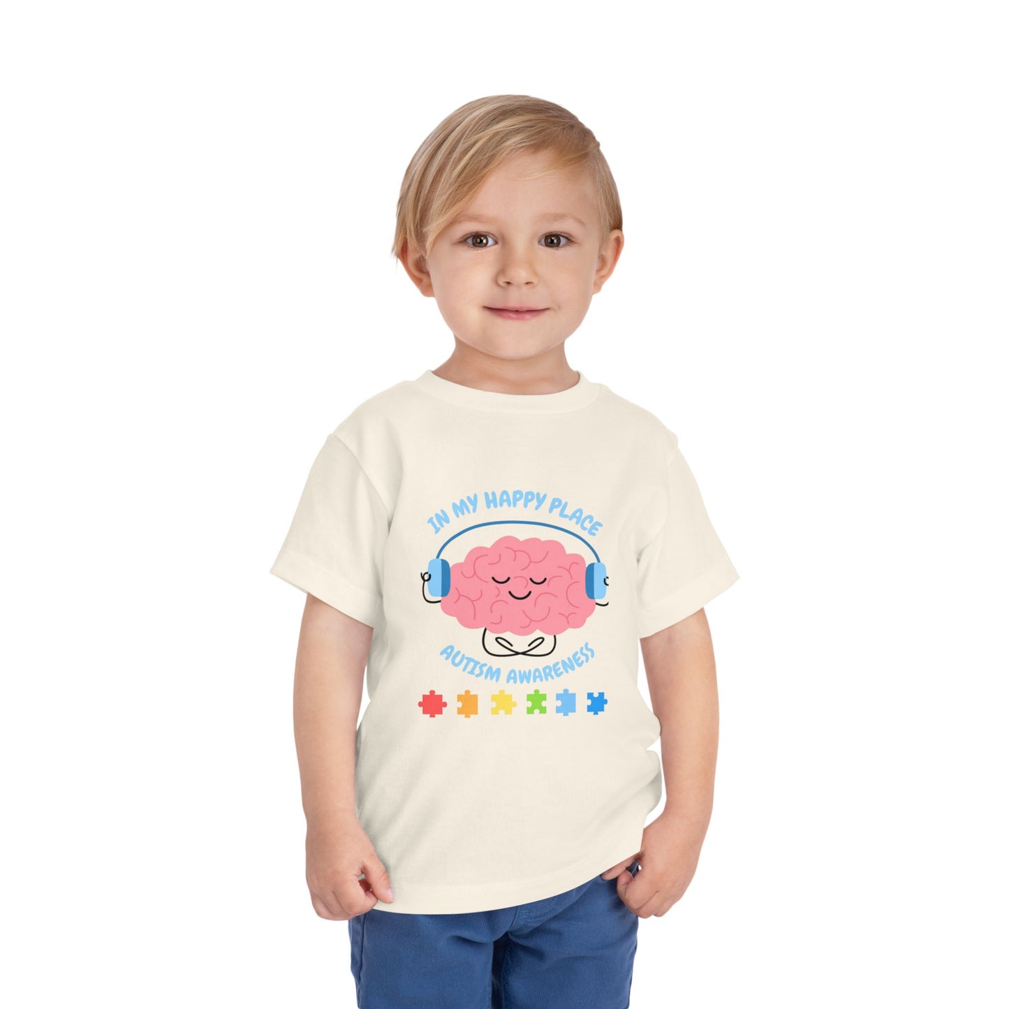 Child wearing a t-shirt with a colorful design on a white background. Shop our comfortable Toddler Tee featuring "In My Happy Place" autism awareness design, perfect for preschool and toddler kids. Natural