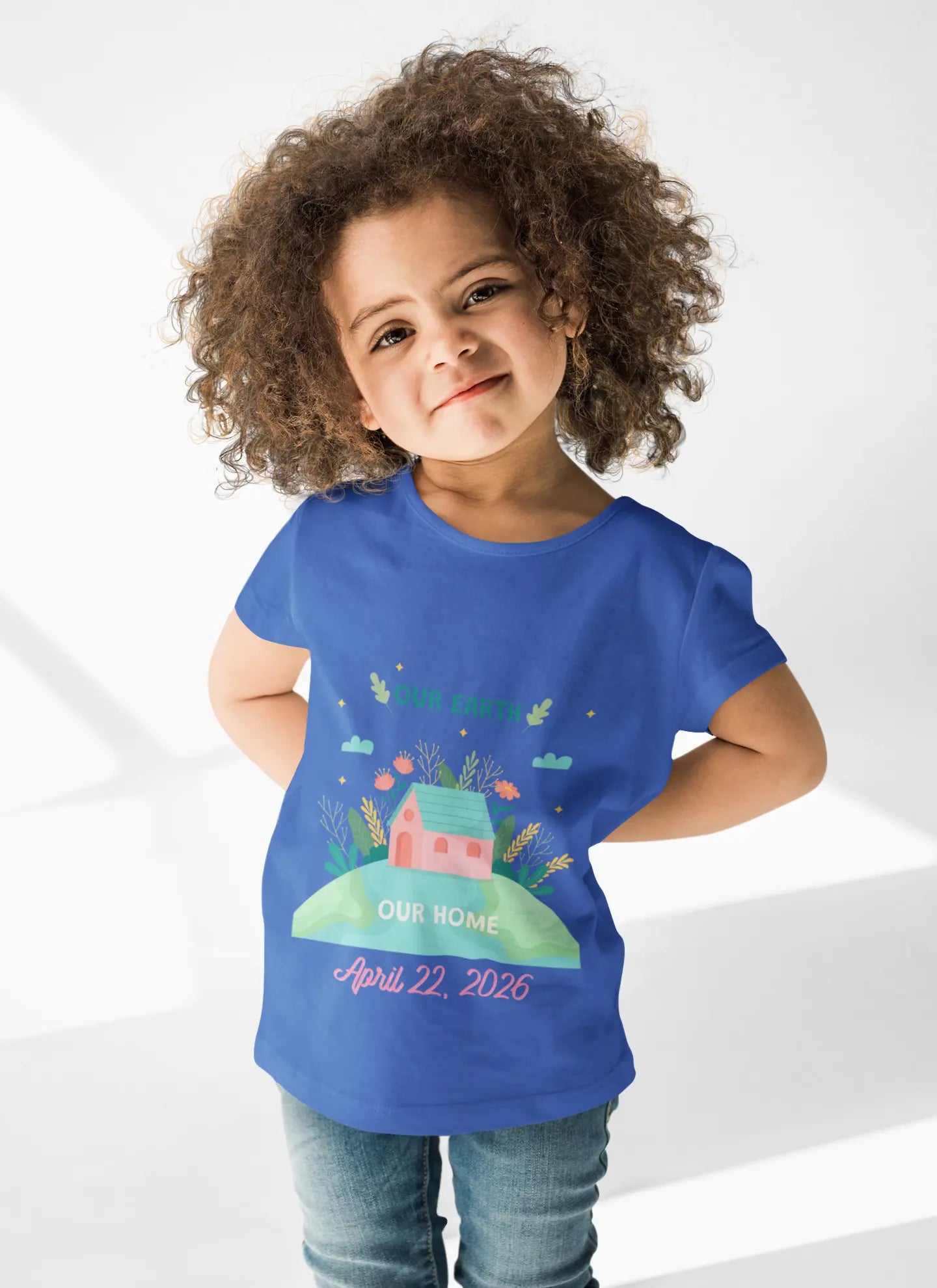 Toddler wearing Our Earth Our Home tee with house on green hill and clouds in True Royal
