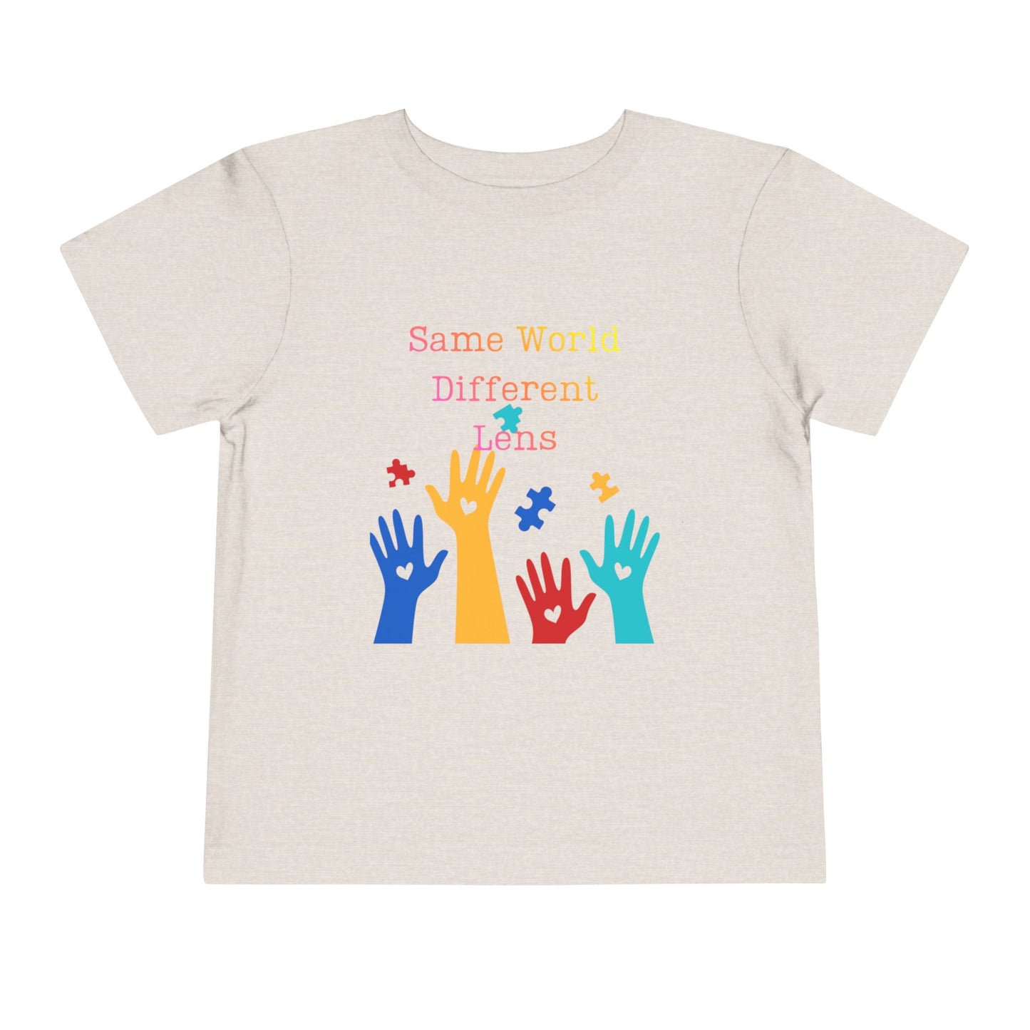 Soft cotton toddler tee with colorful hands, puzzle pieces, and Built Differently message. Celebrates neurodiversity and inclusion. Sizes 2T-5T. Heather Dust
