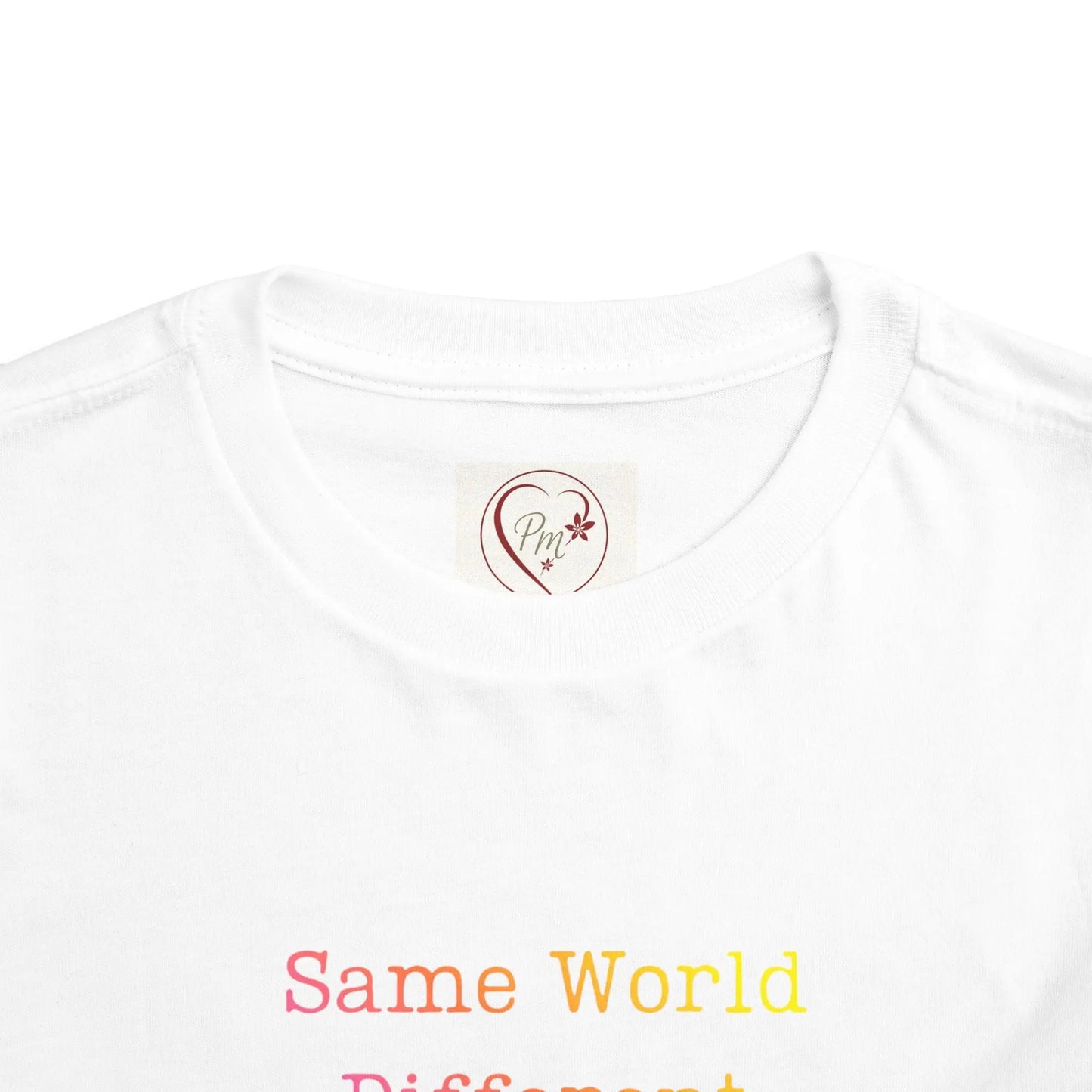 White t-shirt with 'Same World, Different' text and a PM Creations 25 logo on a white background