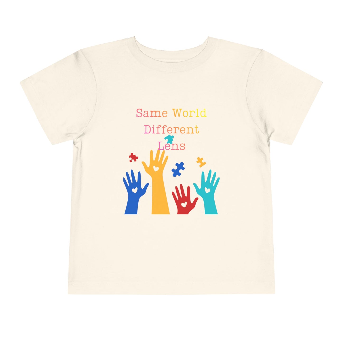 Soft cotton toddler tee with colorful hands, puzzle pieces, and Built Differently message. Celebrates neurodiversity and inclusion. Sizes 2T-5T. Natural
