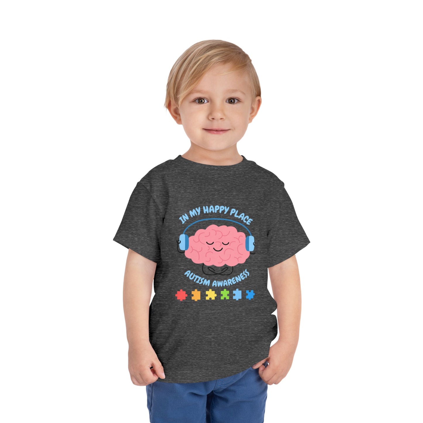 Child wearing a dark gray t-shirt with autism awareness design on a white background. Shop our comfortable Toddler Tee featuring "In My Happy Place" autism awareness design, perfect for preschool and toddler kids.  Deep Heather