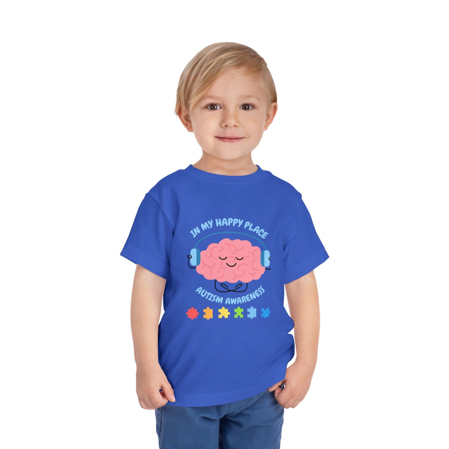 Child wearing a blue t-shirt with a brain graphic and text on a white background. Shop our comfortable Toddler Tee featuring "In My Happy Place" autism awareness design, perfect for preschool and toddler kids. True Royal