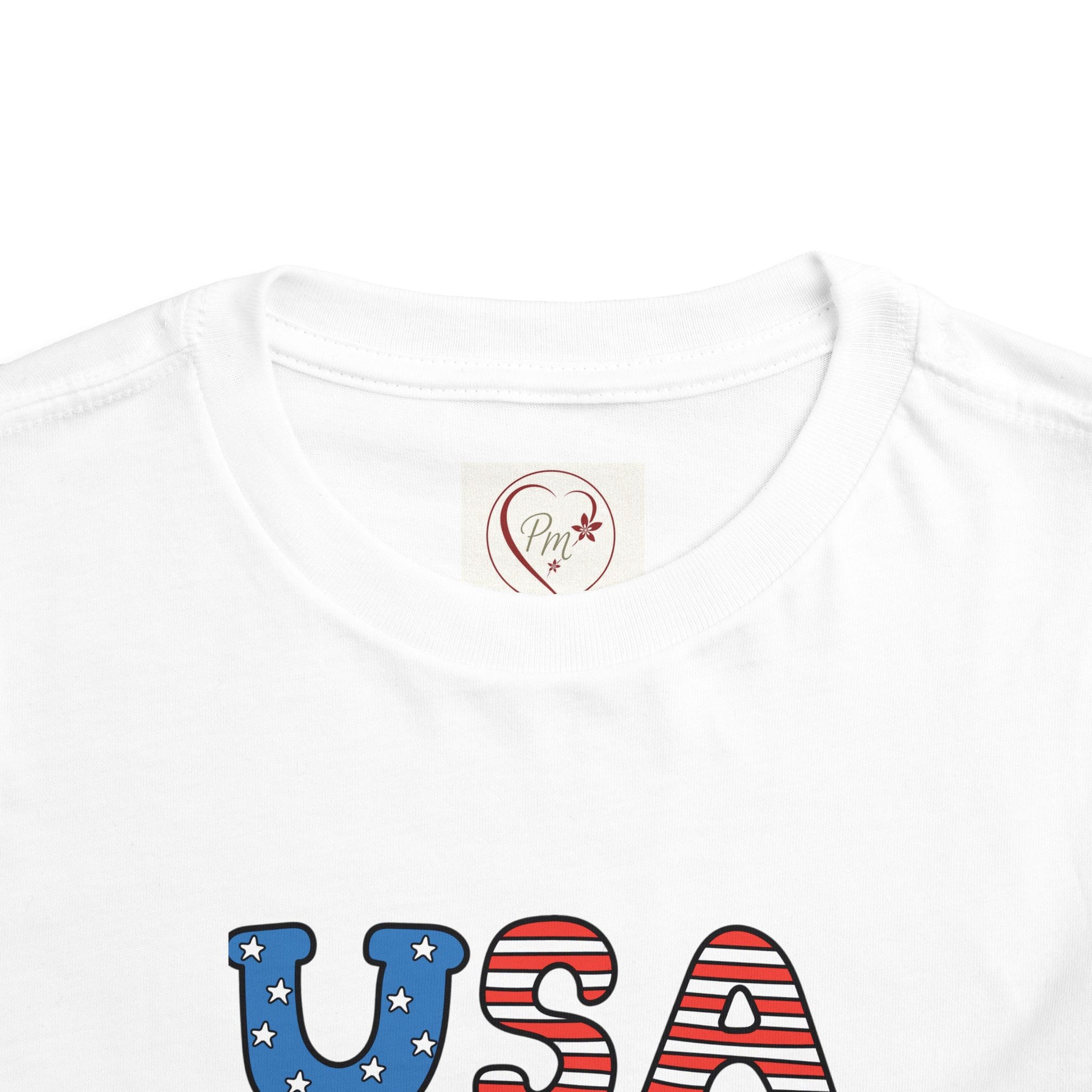 White t-shirt with 'USA' text in red, white, and blue on a white background, with a PM Creations 25 Logo on the neckline