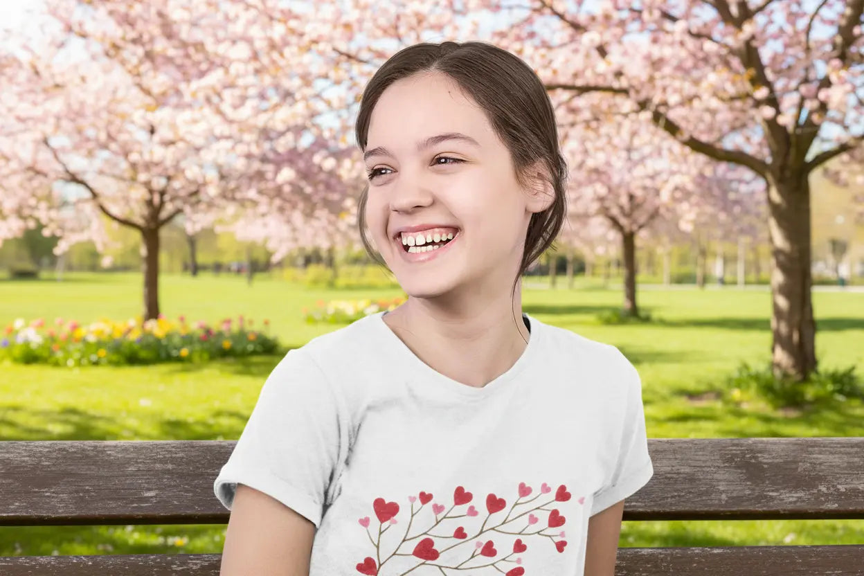 Youth wearing Valentine's Day tee with heart-shaped leaves on branch design, White
