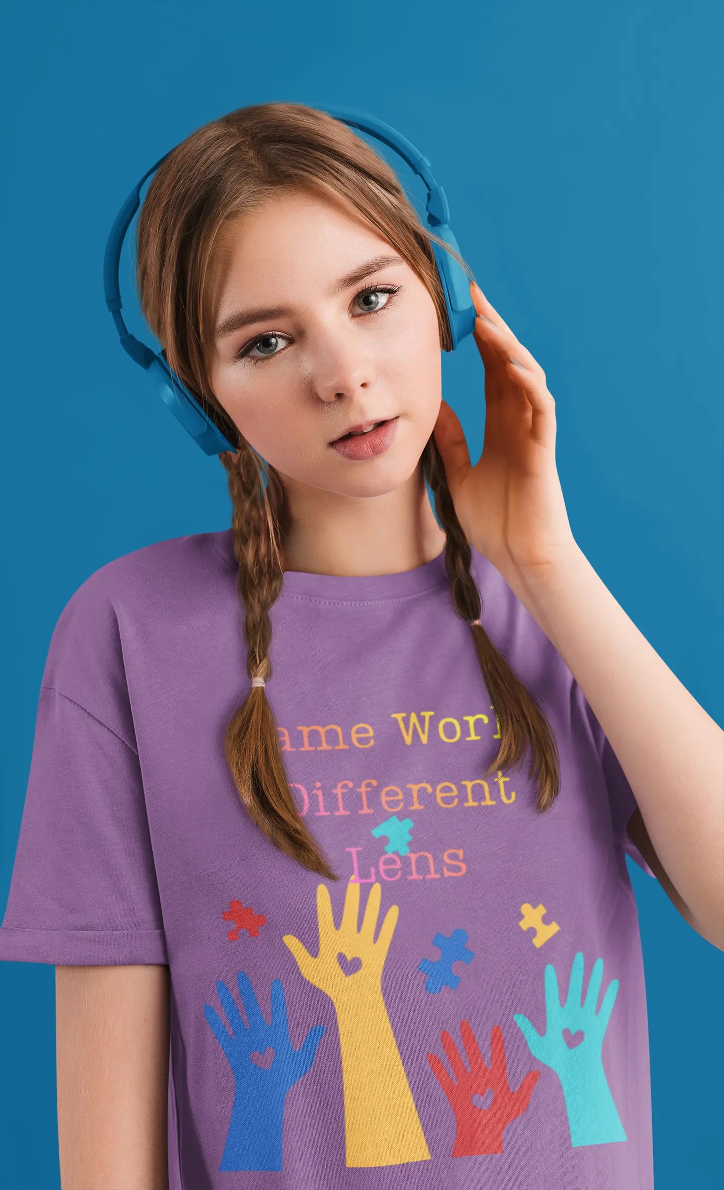 Youth wearing Same World Different Lens tee with colorful handprints and autism awareness design, Heather Team Purple
